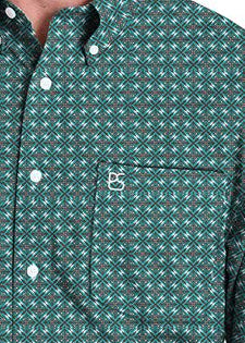 Close up of a green long-sleeve button-down shirt with a small white geometric pattern.