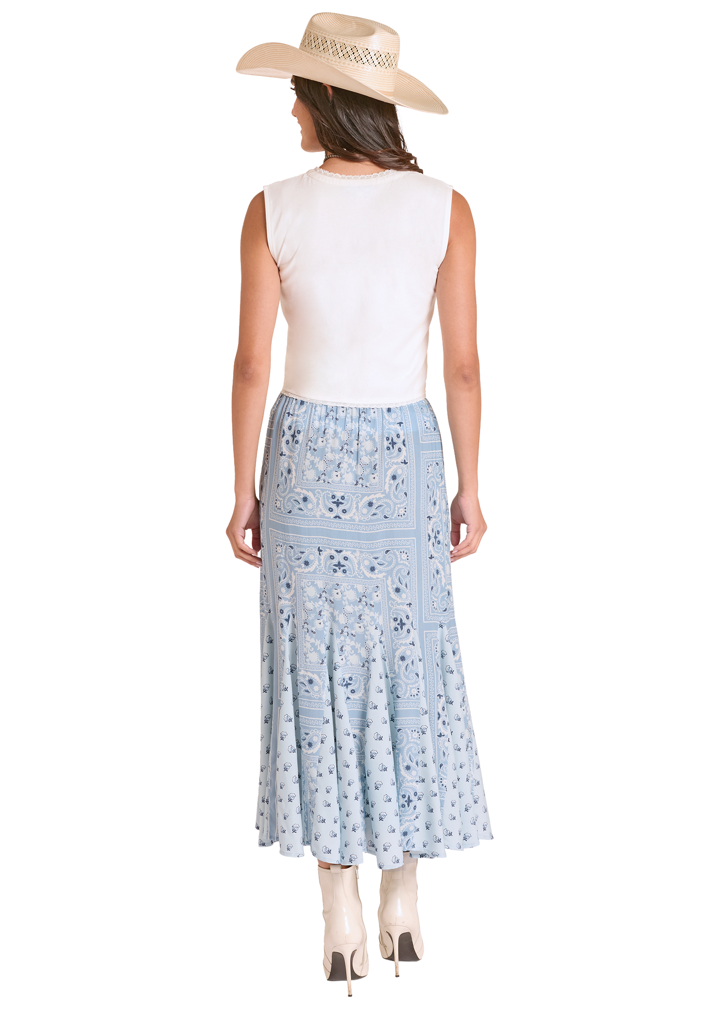 Woman wearing a white sleeveless top and light blue floral skirt with a beige hat on a white background