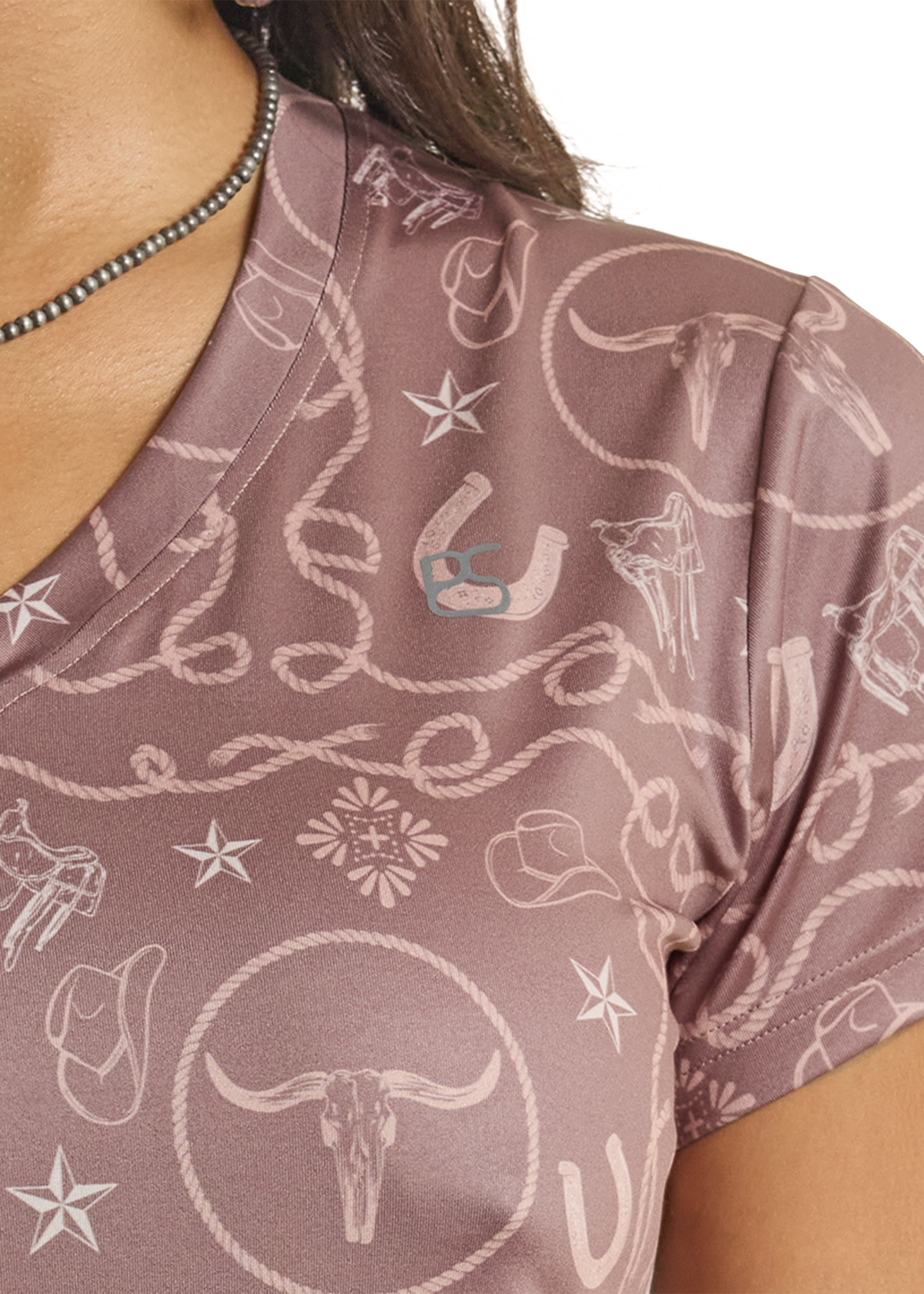 Close-up of a brown shirt with white patterns and a visible brand logo.