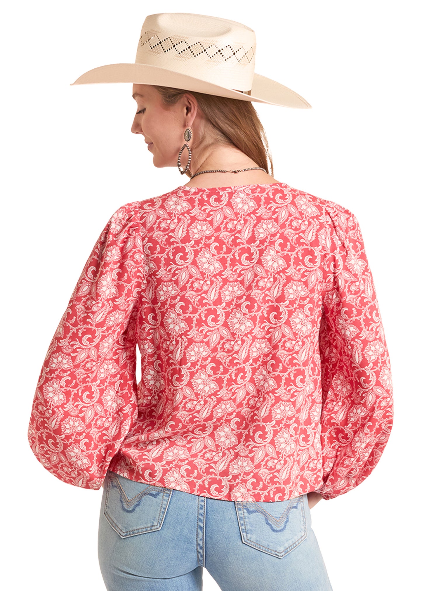 Person wearing a red floral blouse and beige cowboy hat on a white background