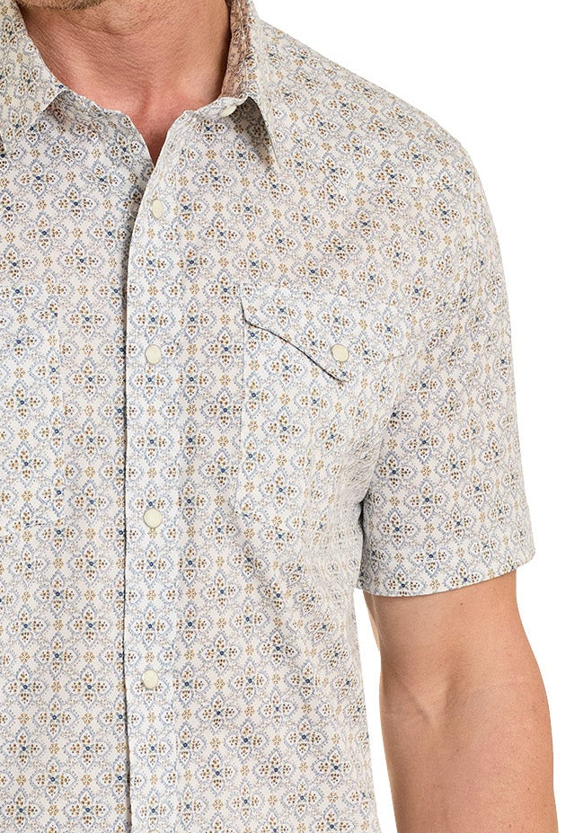 Man wearing a Western snap shirt with a floral medallion print and a cowboy hat