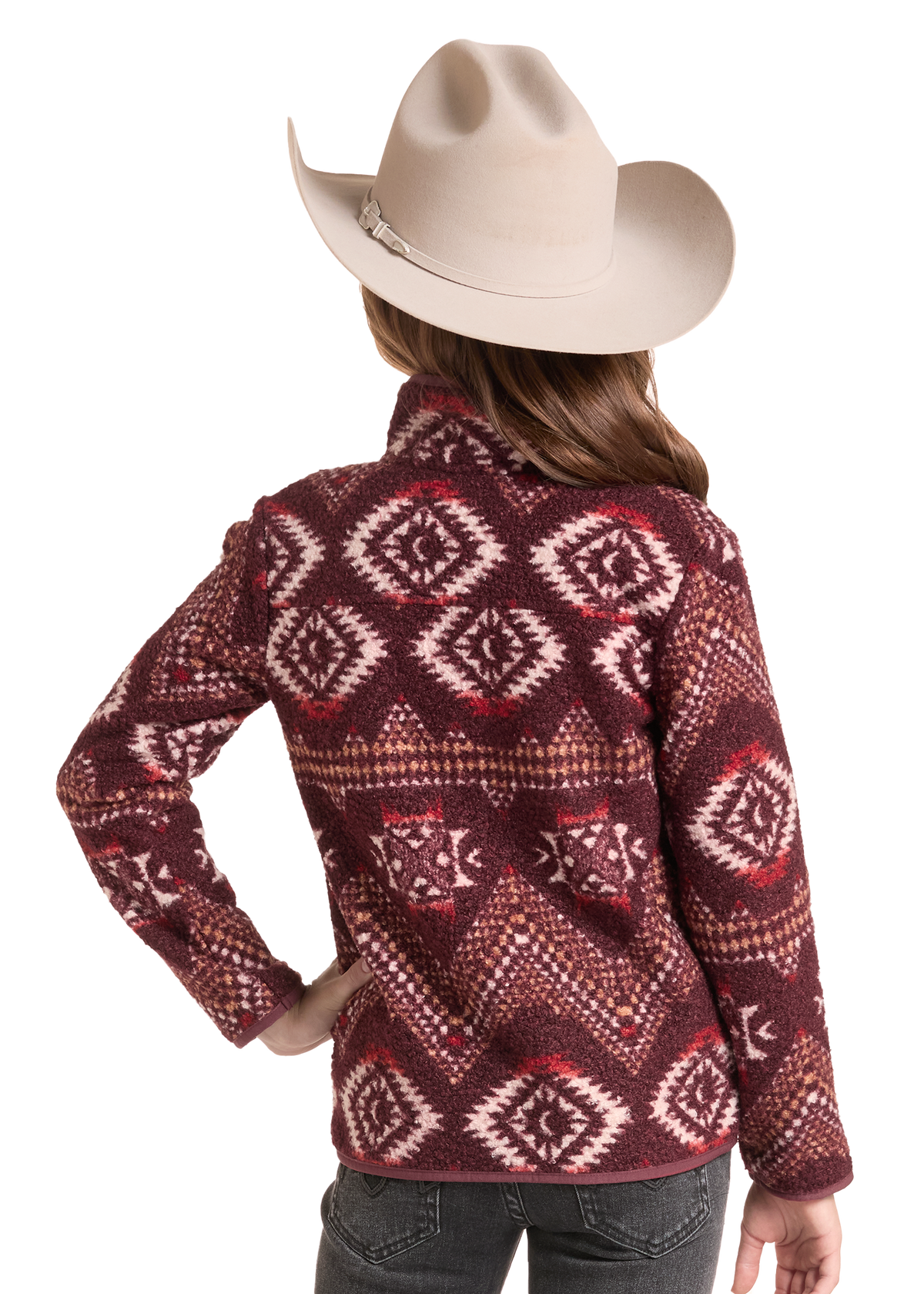 A child model shown from the back wearing a cream cowboy hat and a long-sleeve fleece pullover with a red, brown, and cream geometric Southwestern pattern, paired with black jeans.