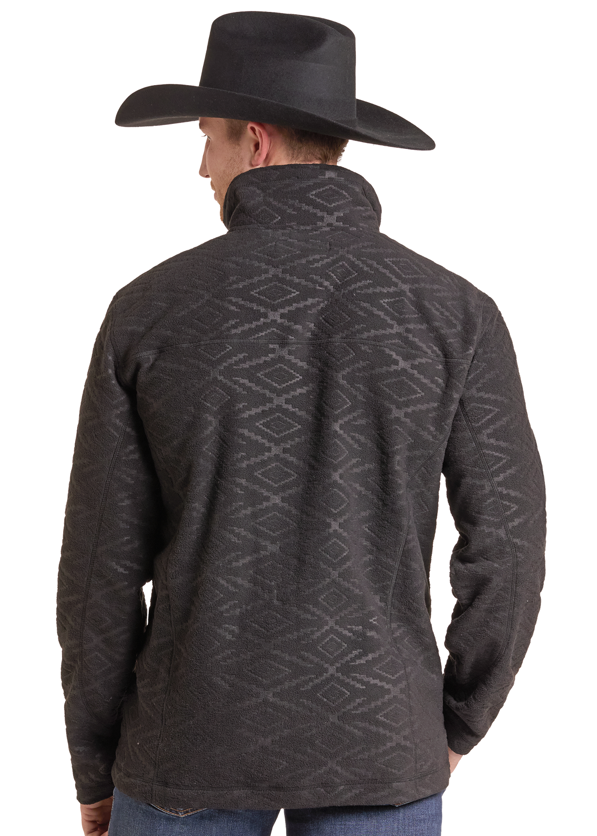 A man shown from the back wearing a dark charcoal gray fleece pullover with a subtle geometric diamond pattern, paired with a black cowboy hat and blue jeans.
