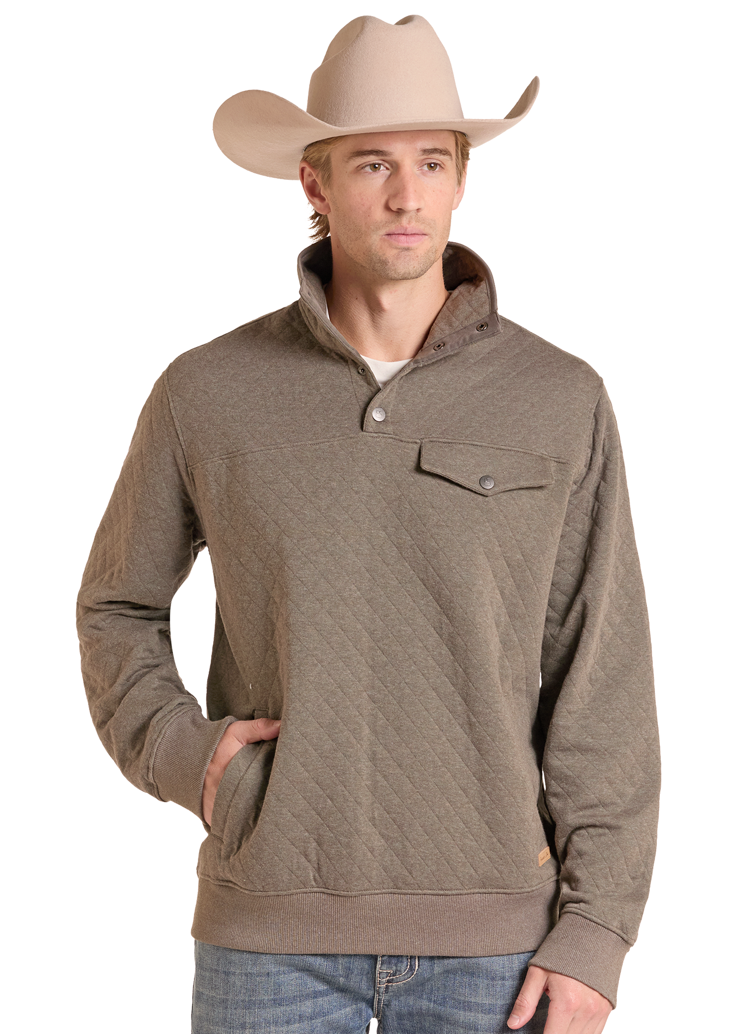 A man wearing a taupe-brown quilted long-sleeve pullover sweater with a stand collar and chest pocket, paired with a beige cowboy hat and blue jeans.