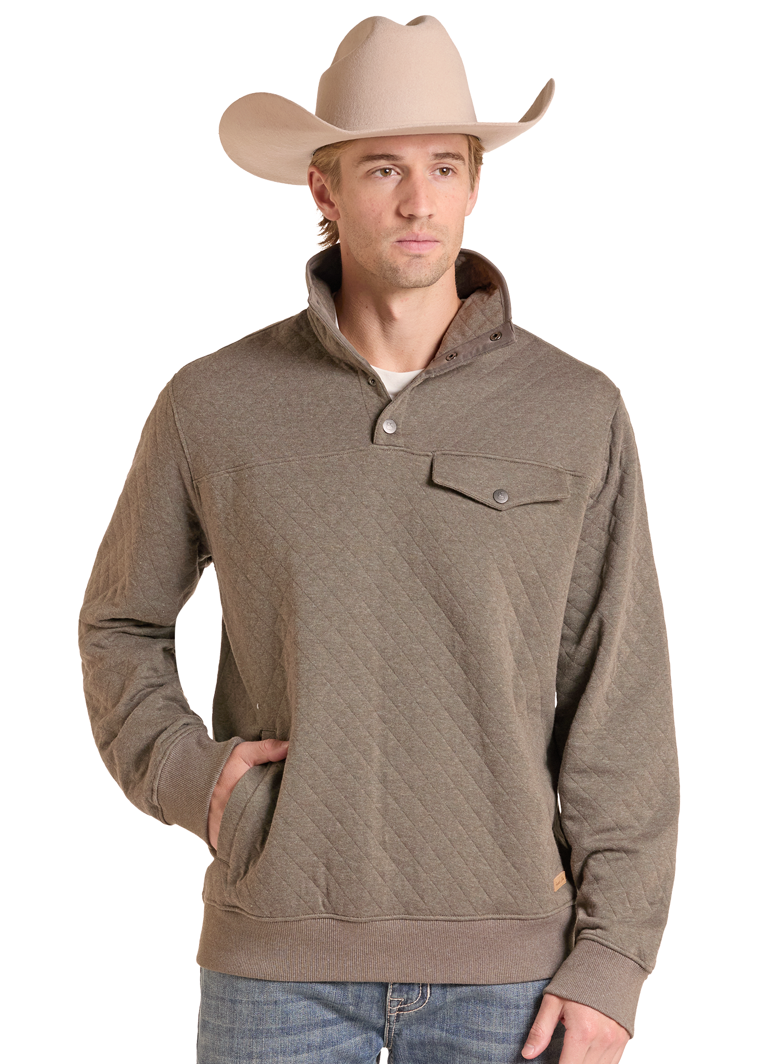 A man wearing a taupe-brown quilted long-sleeve pullover sweater with a stand collar and chest pocket, paired with a beige cowboy hat and blue jeans.