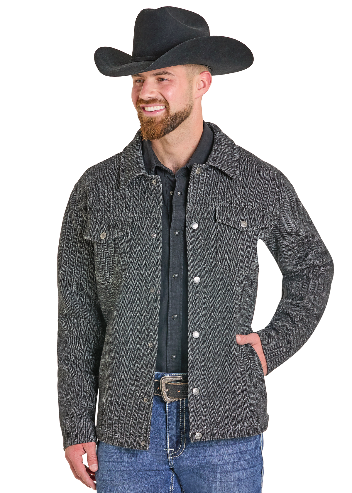 A man wearing a dark gray textured western-style jacket over a black shirt, blue jeans, and a black cowboy hat.