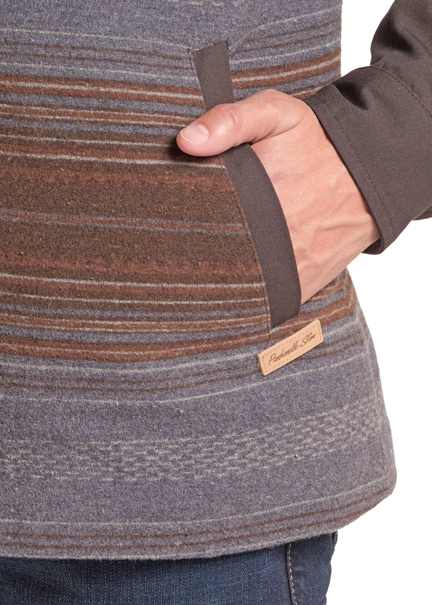 Close-up of a person wearing a striped fleece jacket in gray, brown, and rust tones, with a hand inserted into a side pocket.