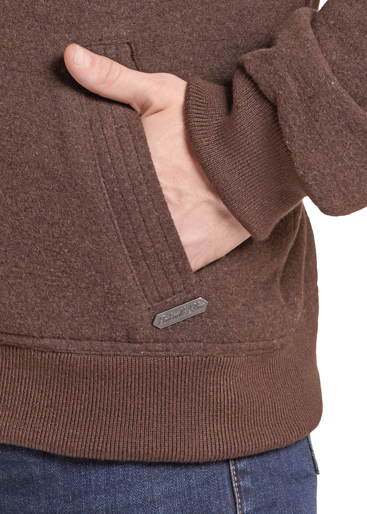 Close-up of a person wearing a brown ribbed knit hoodie with a side pocket, hand in pocket.