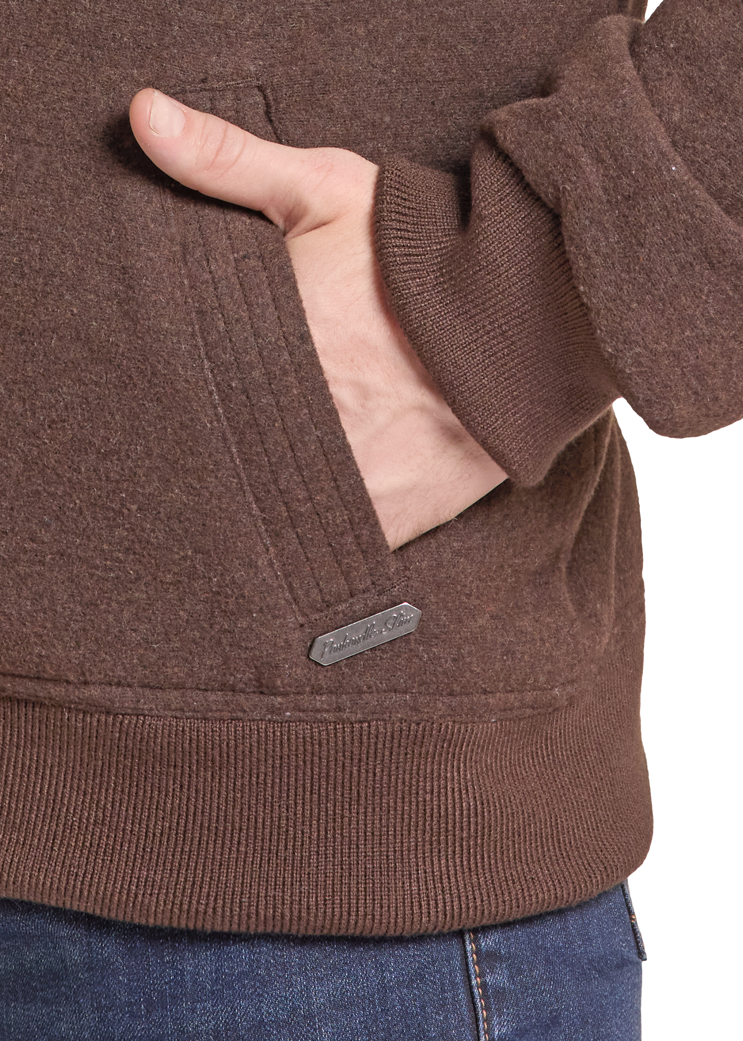 Close-up of a person wearing a brown ribbed knit hoodie with a side pocket, hand in pocket.