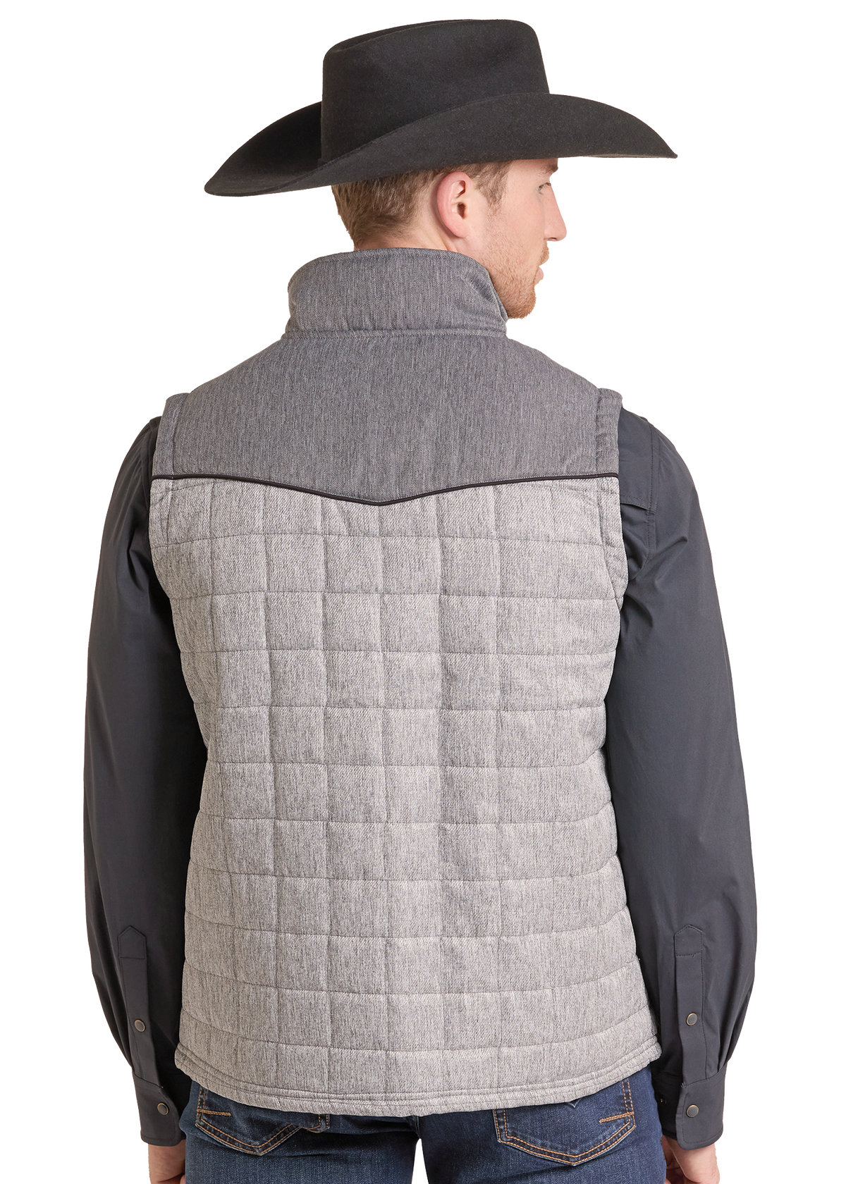 A man shown from the back wearing a light gray quilted puffer vest over a dark gray long-sleeve shirt and blue jeans, with a black cowboy hat.