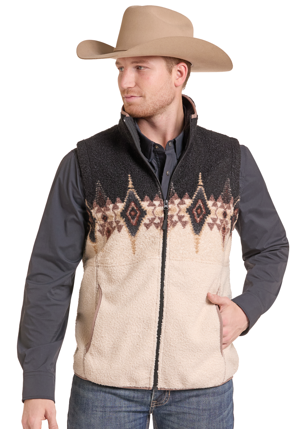 A man wearing a beige cowboy hat, a dark gray long-sleeve shirt, and a beige sherpa fleece vest with a black and brown geometric pattern across the chest.