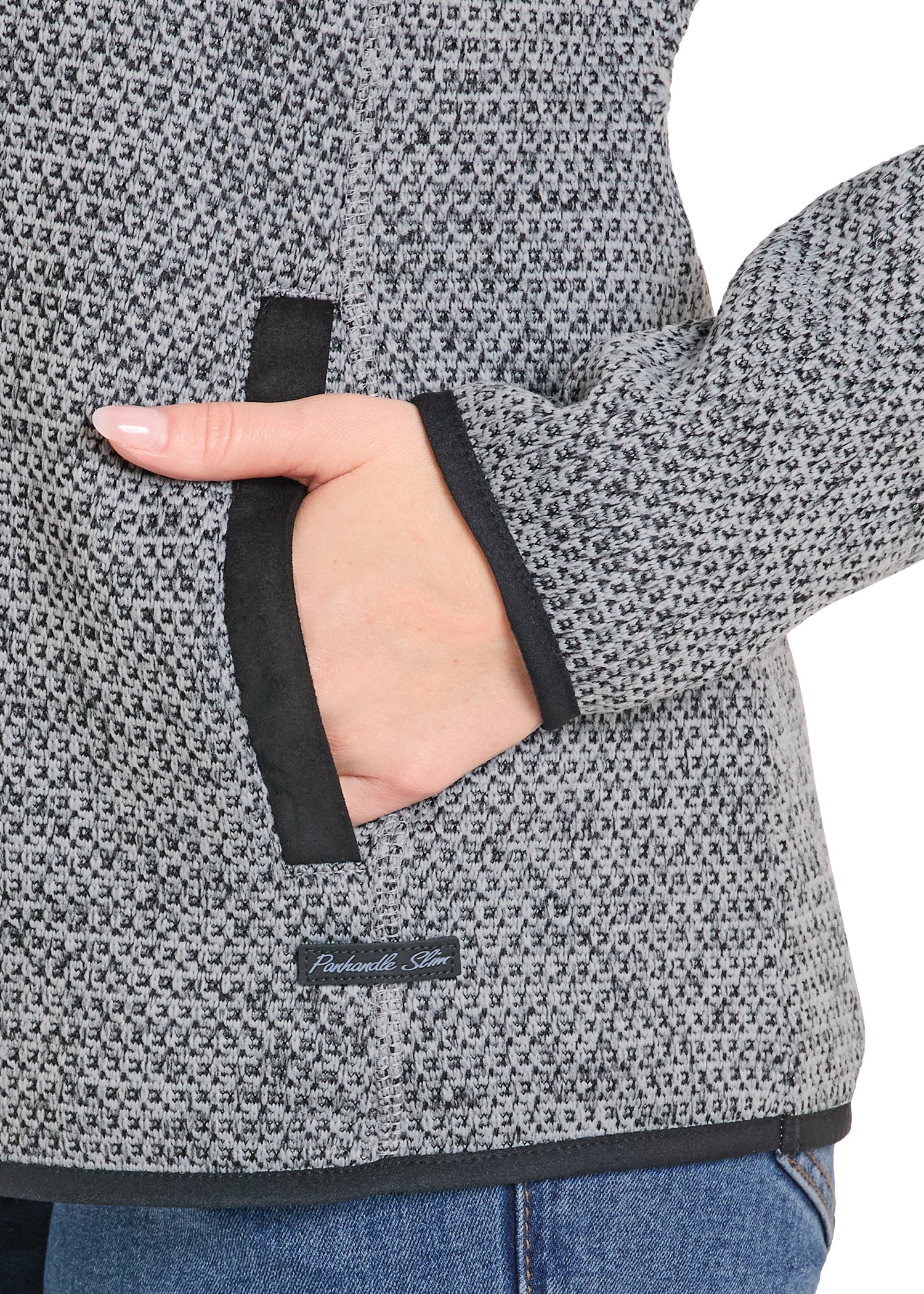 Close-up of a hand wearing a gray patterned fleece jacket with a brand label.