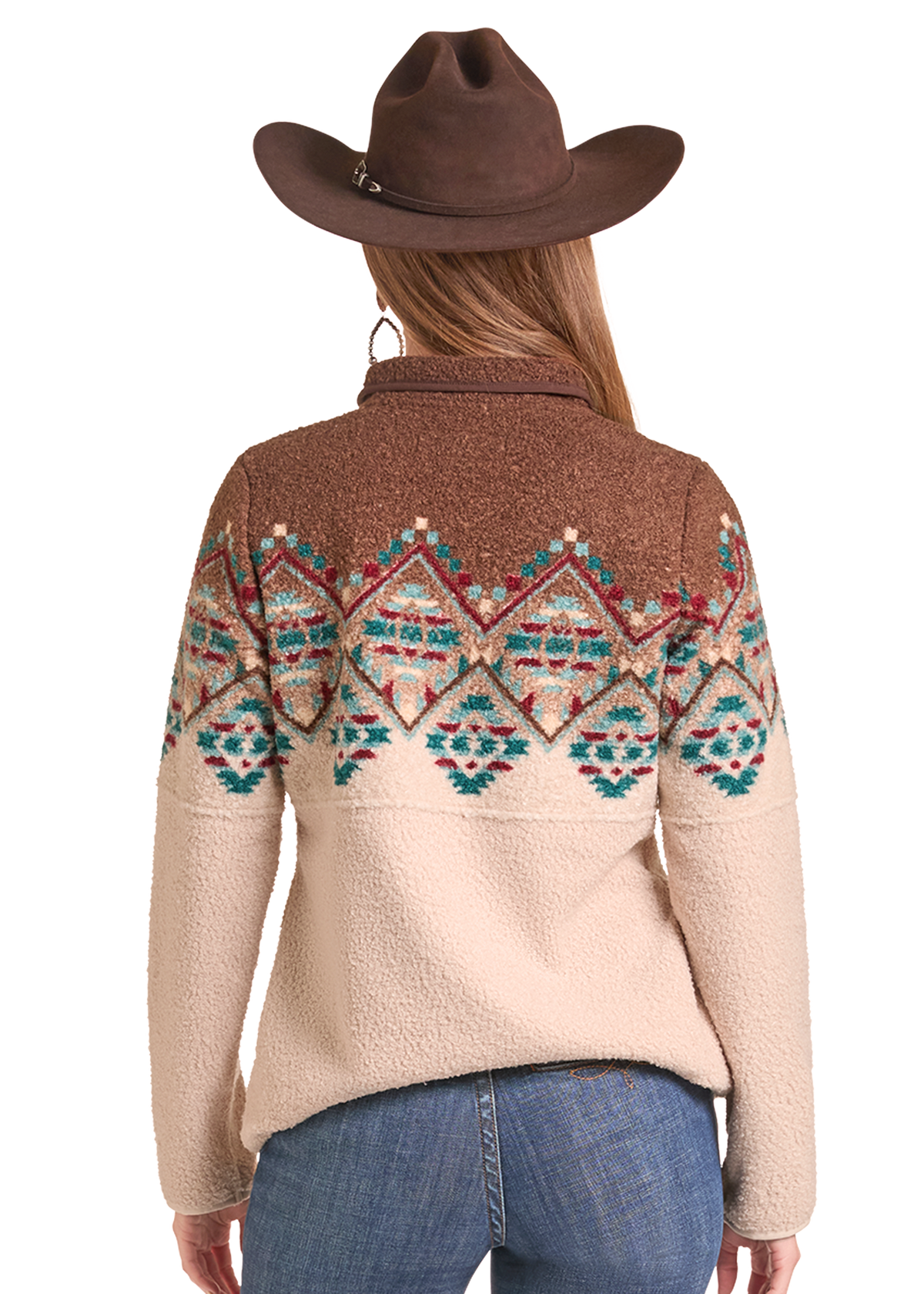 Rear view of a woman wearing a brown cowboy hat and a sherpa fleece quarter-zip sweater with a brown yoke and a multicolor geometric pattern across the upper back and shoulders, paired with blue jeans.