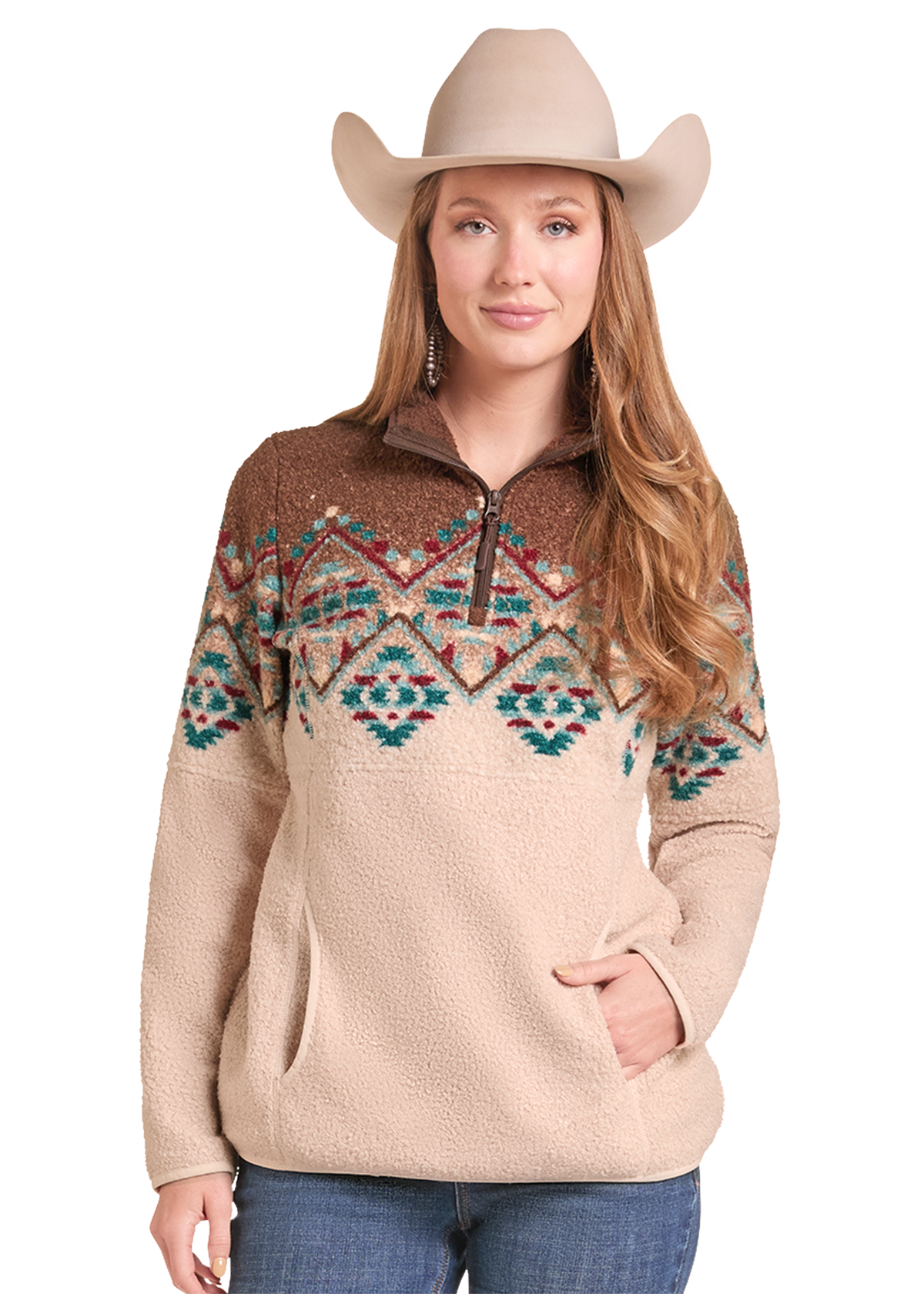 A woman wearing a beige cowboy hat and a sherpa pullover sweater with a brown yoke and a colorful geometric pattern across the chest, paired with blue jeans.