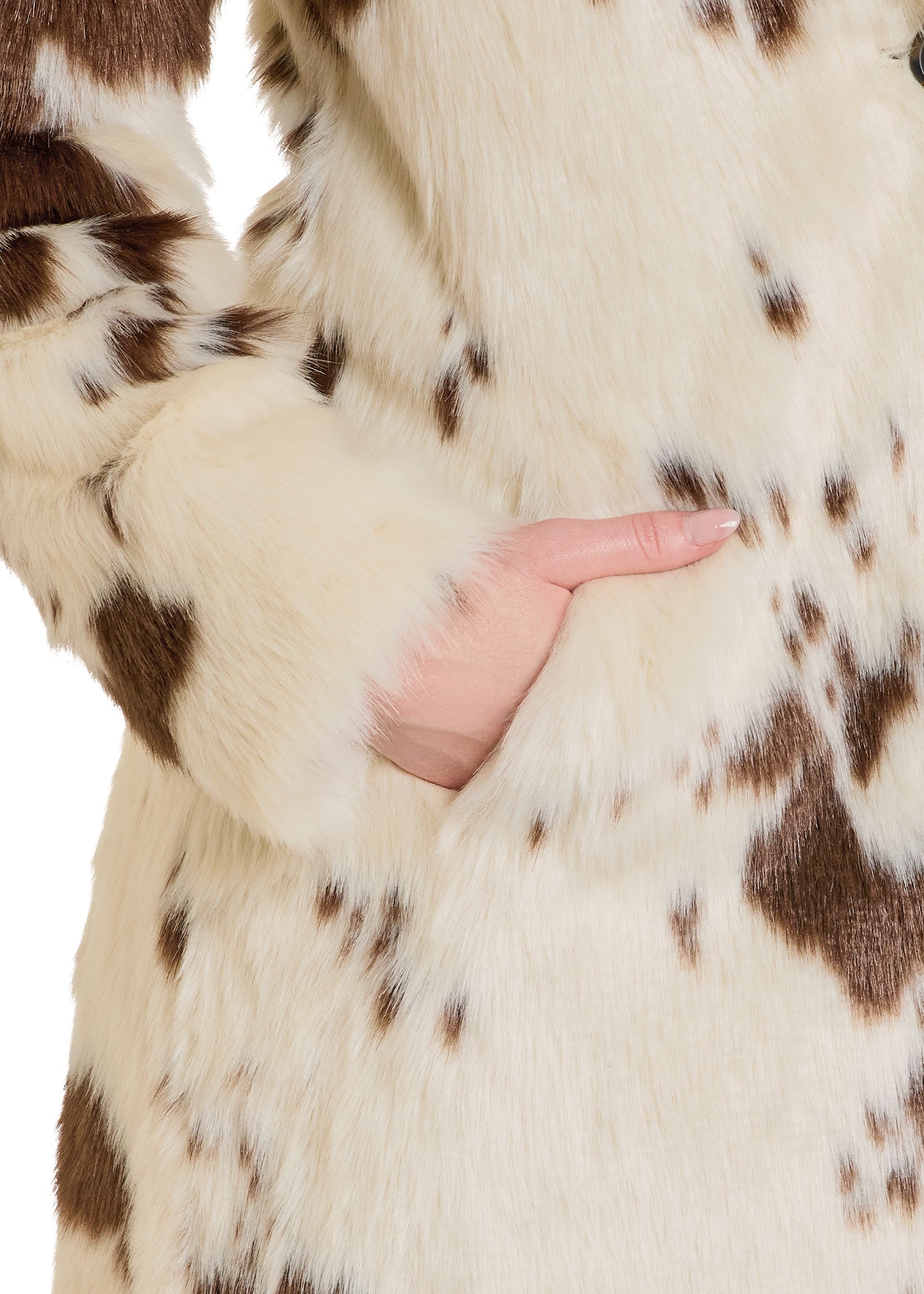 Close-up of a brown and white fur coat with a hand touching the fabric.