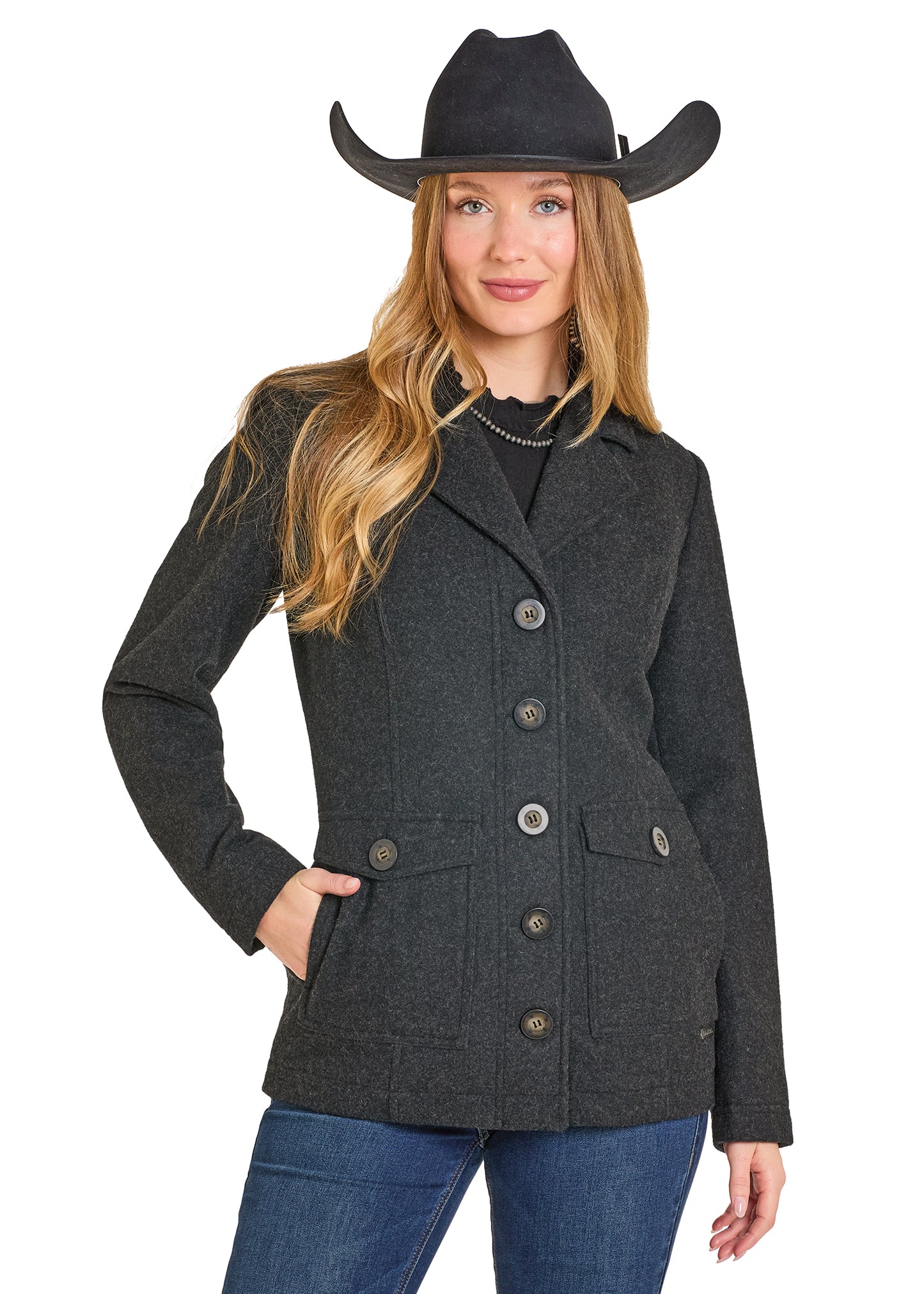 Woman wearing a dark gray jacket with buttons, blue jeans, and a black cowboy hat on a white background