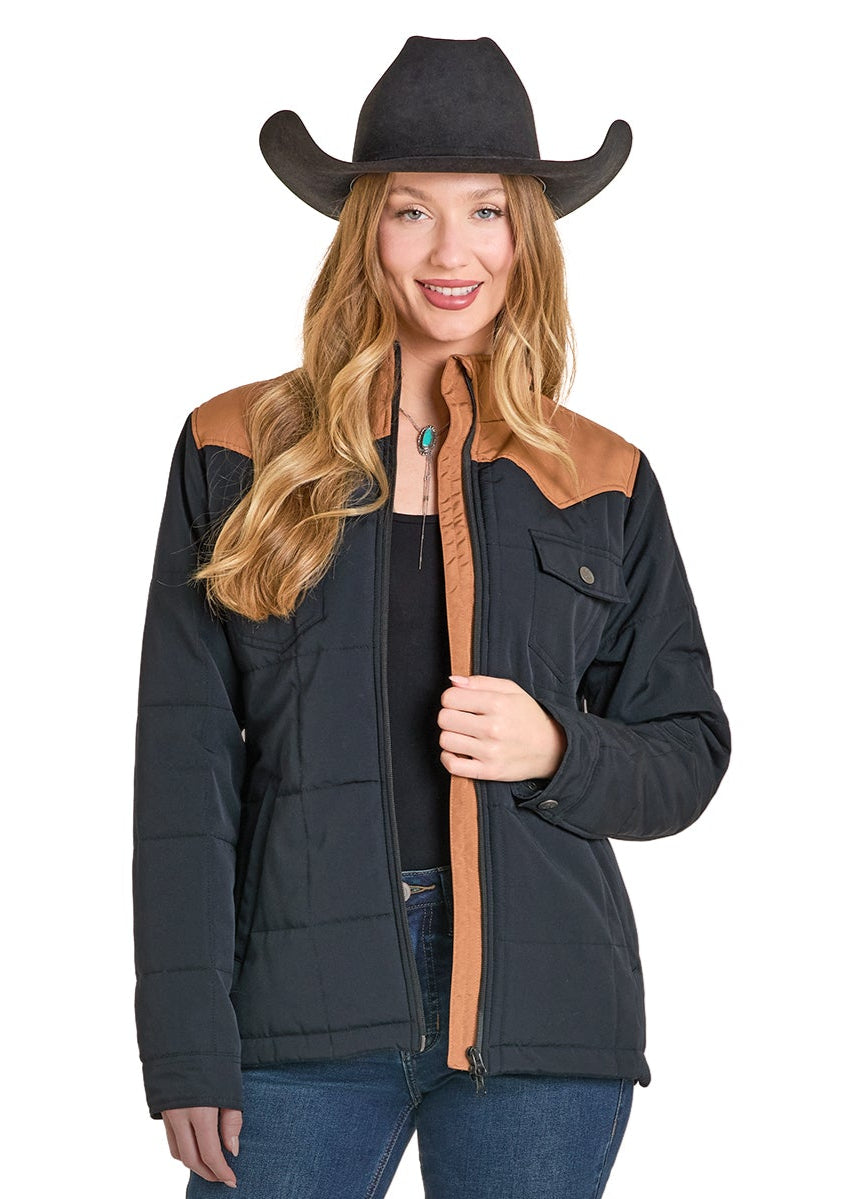 Woman wearing a black jacket with brown accents, blue jeans, and a cowboy hat on a white background