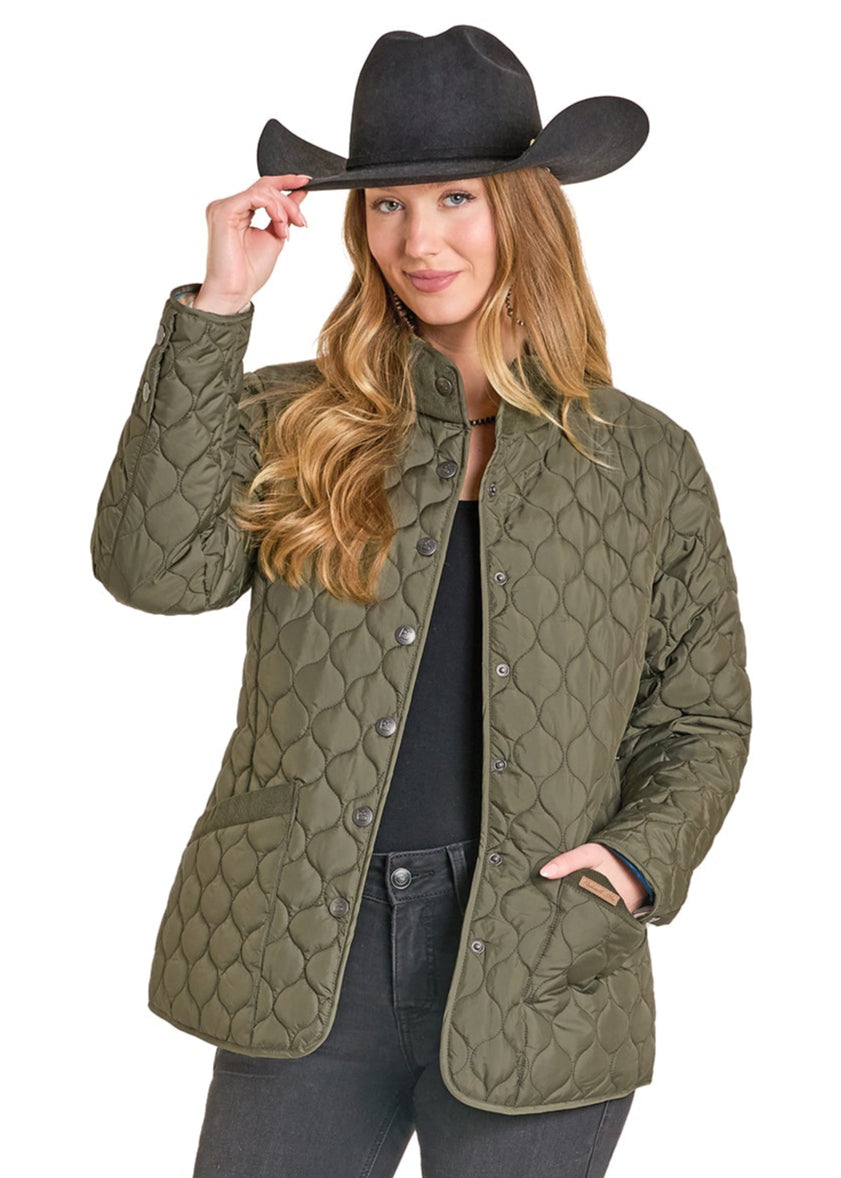 Woman wearing a green quilted jacket and black cowboy hat on a white background