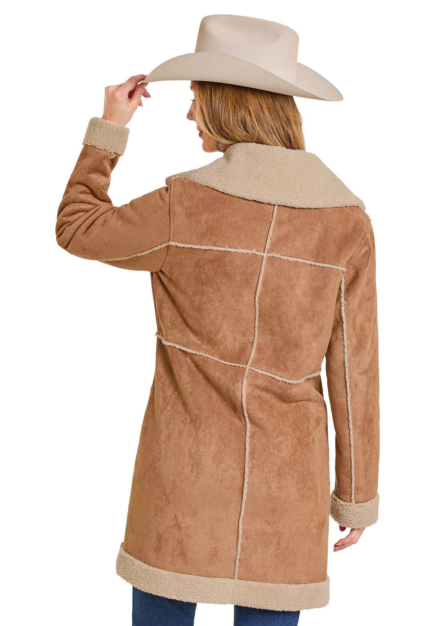Person wearing a brown suede coat with white stitching and a beige cowboy hat on a white background