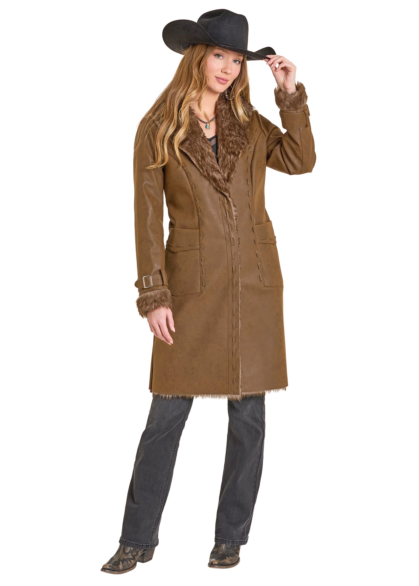 Woman wearing a brown coat with fur trim and a black cowboy hat on a white background