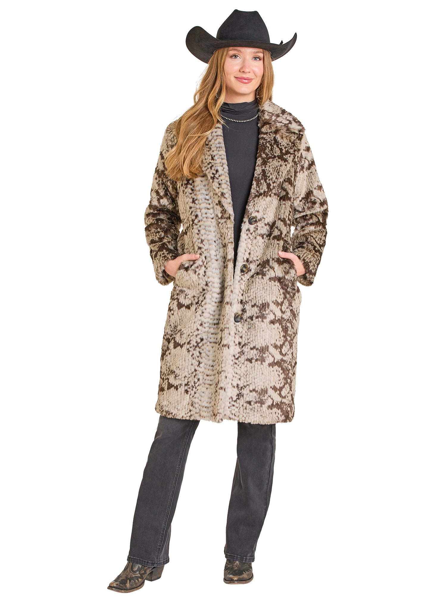 Woman wearing a patterned coat and cowboy hat on a white background