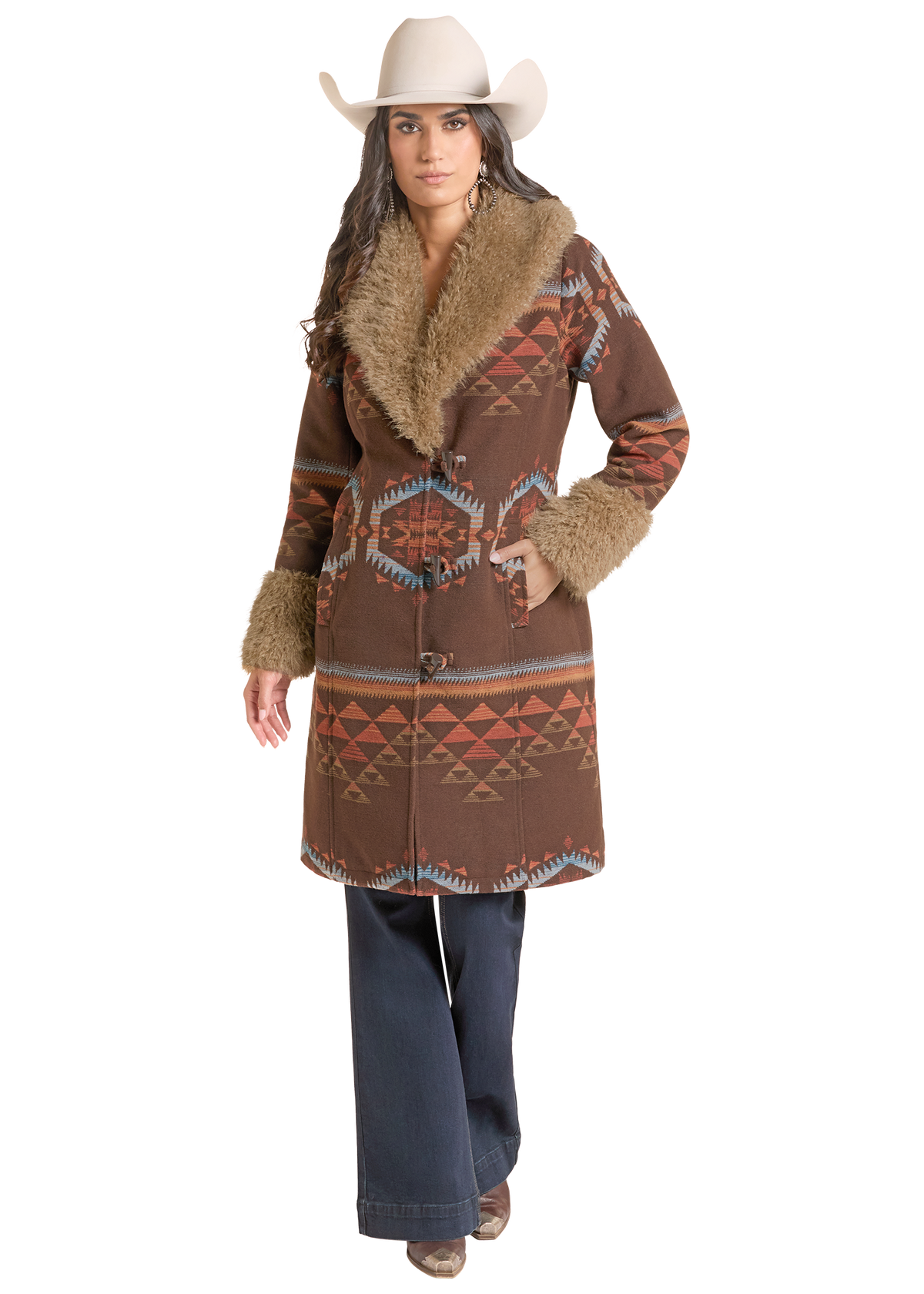A woman modeling a brown patterned western-style coat with tan faux-fur trim, a white cowboy hat, and dark blue jeans.