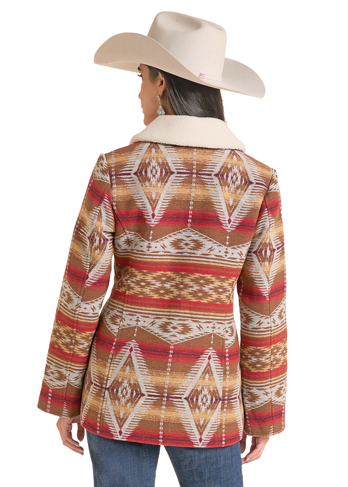 A woman shown from the back wearing a western-style patterned jacket with a cream sherpa collar, paired with a cream cowboy hat and blue jeans.