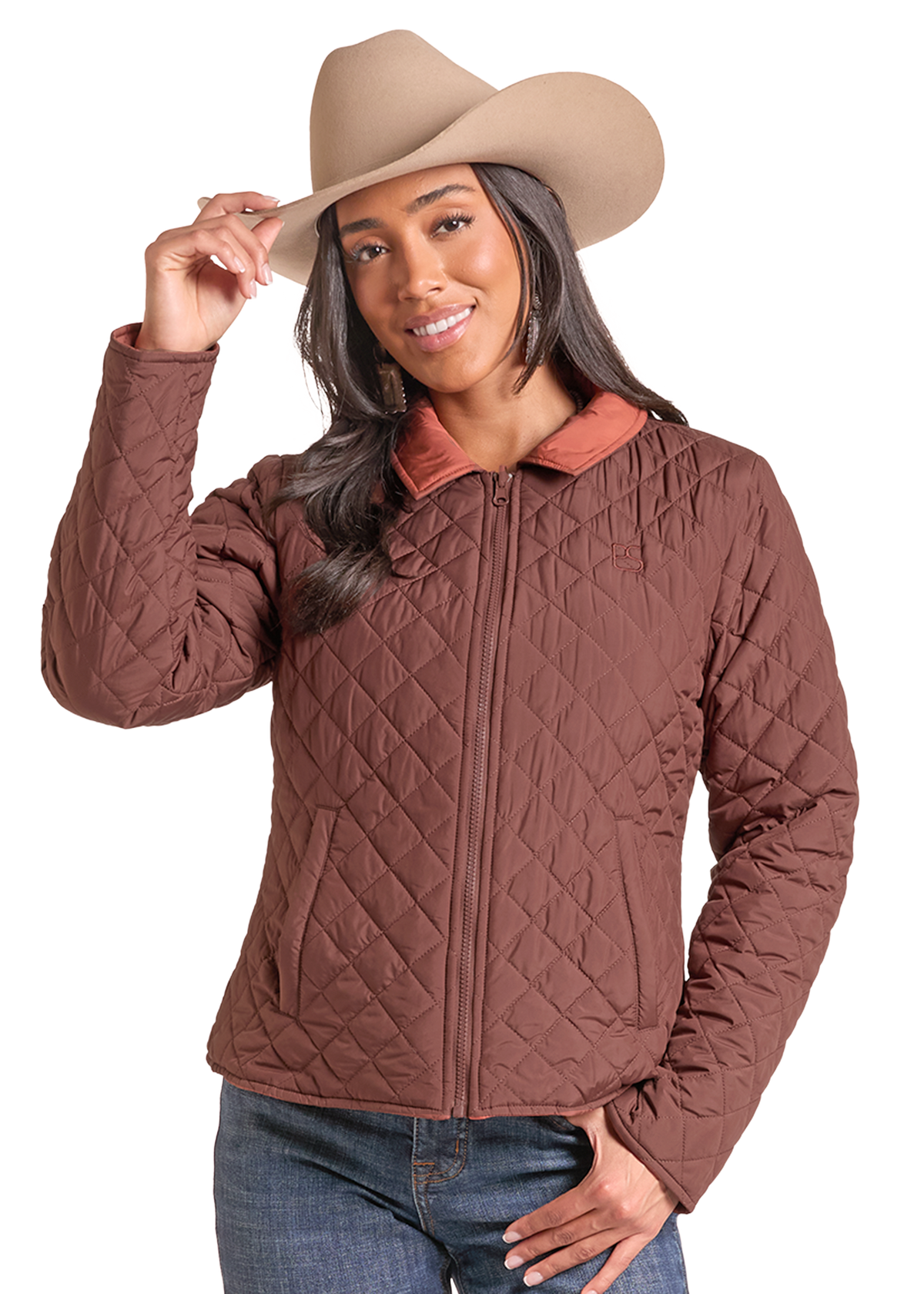 A woman wearing a brown diamond-quilted zip-up jacket with a contrasting tan collar, a tan cowboy hat, and blue jeans.