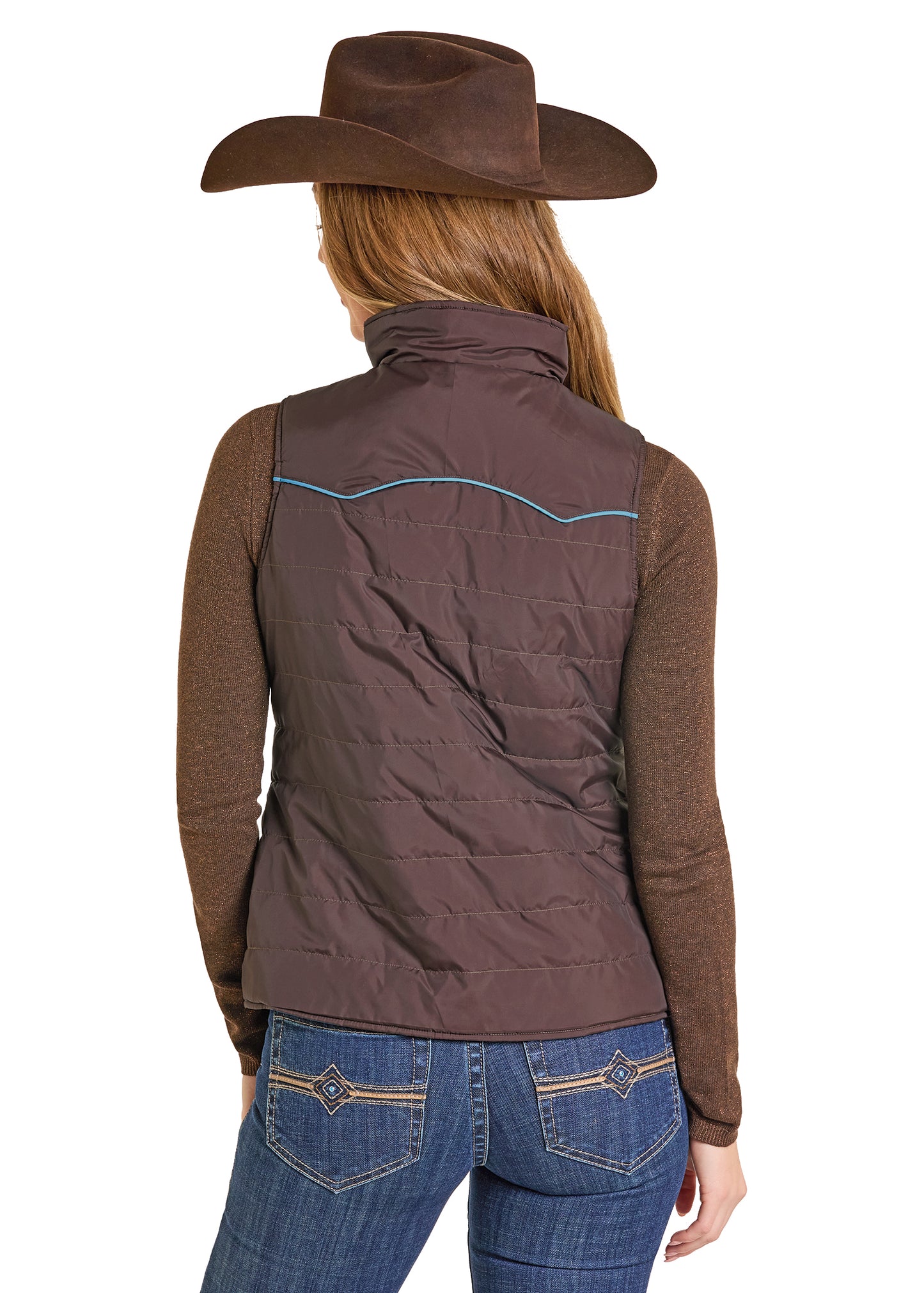 Person wearing a brown quilted vest and blue jeans with a white background