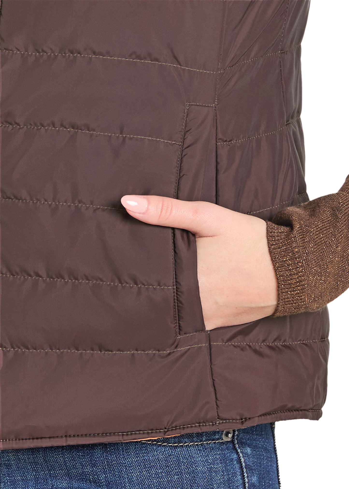 Close-up of a brown quilted jacket with a hand touching the fabric