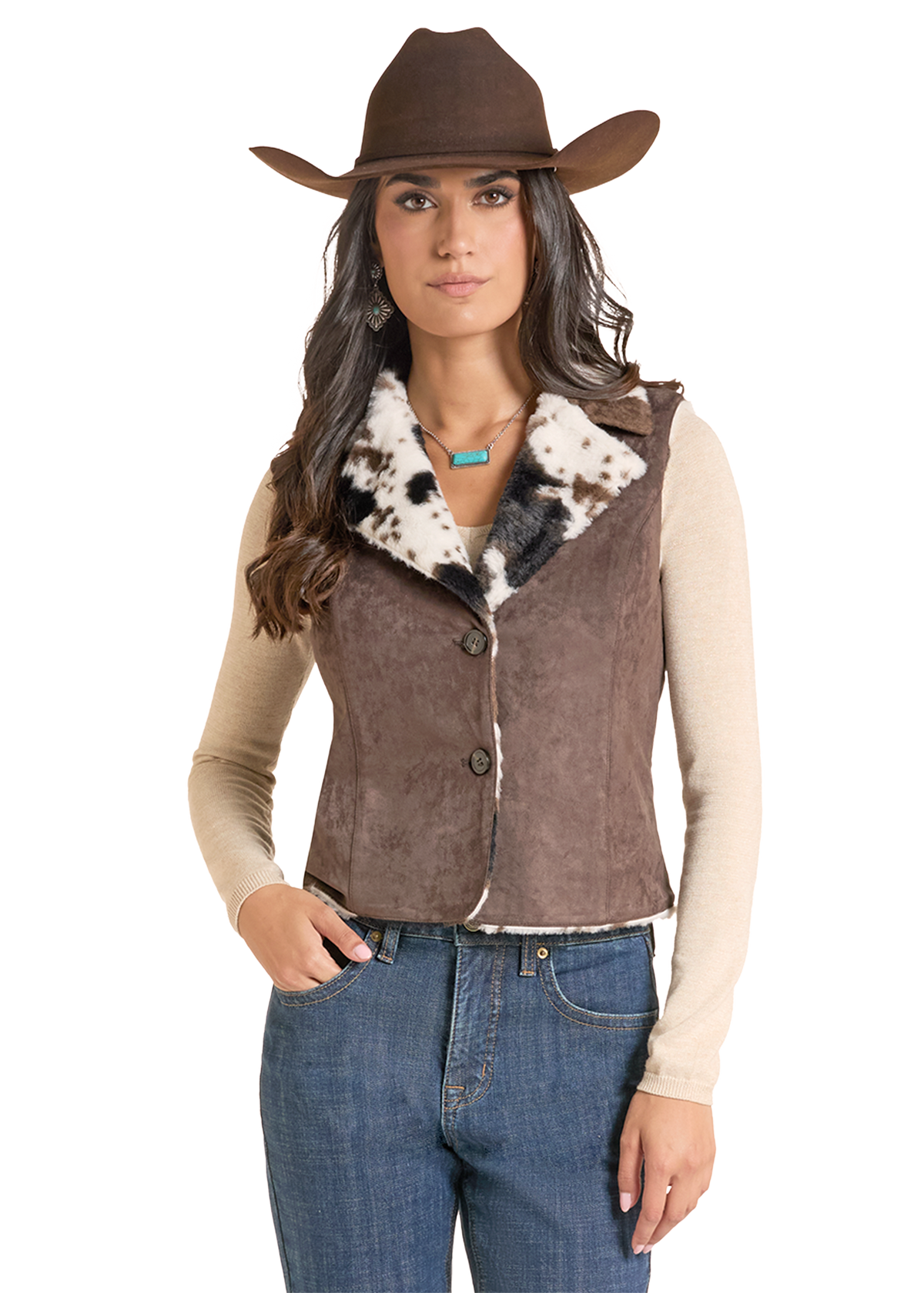 A woman modeling a brown suede-like western vest with a black and white cowhide-patterned faux fur collar, styled with a brown cowboy hat.