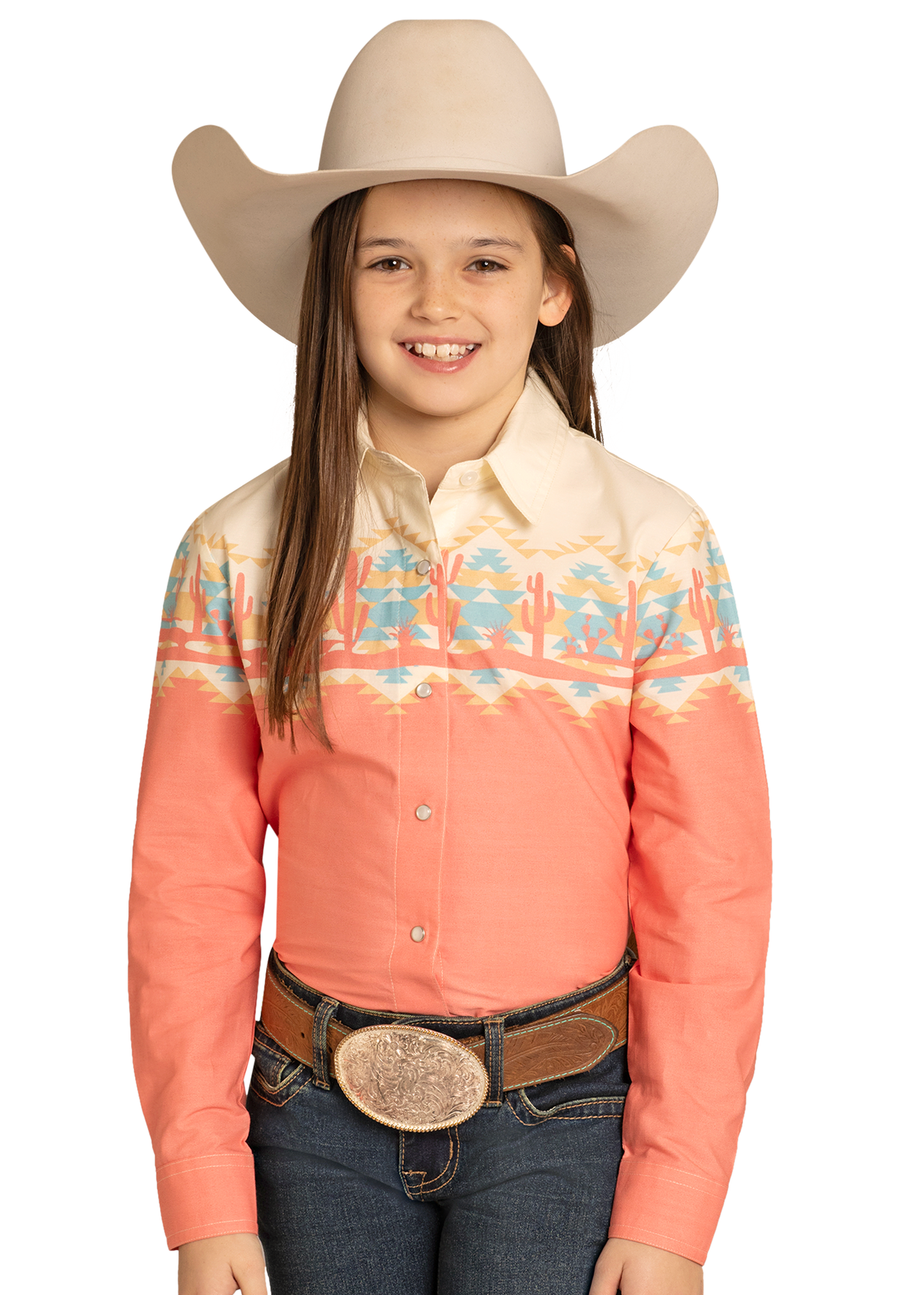 Young girl wearing a coral embroidered shirt, blue jeans, and a beige cowboy hat on a white background