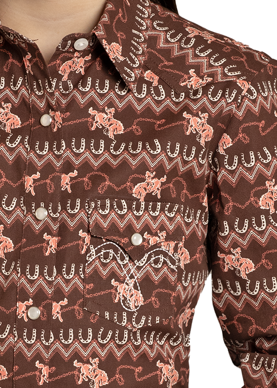 Young girl wearing a patterned brown shirt, jeans, and a beige cowboy hat on a white background