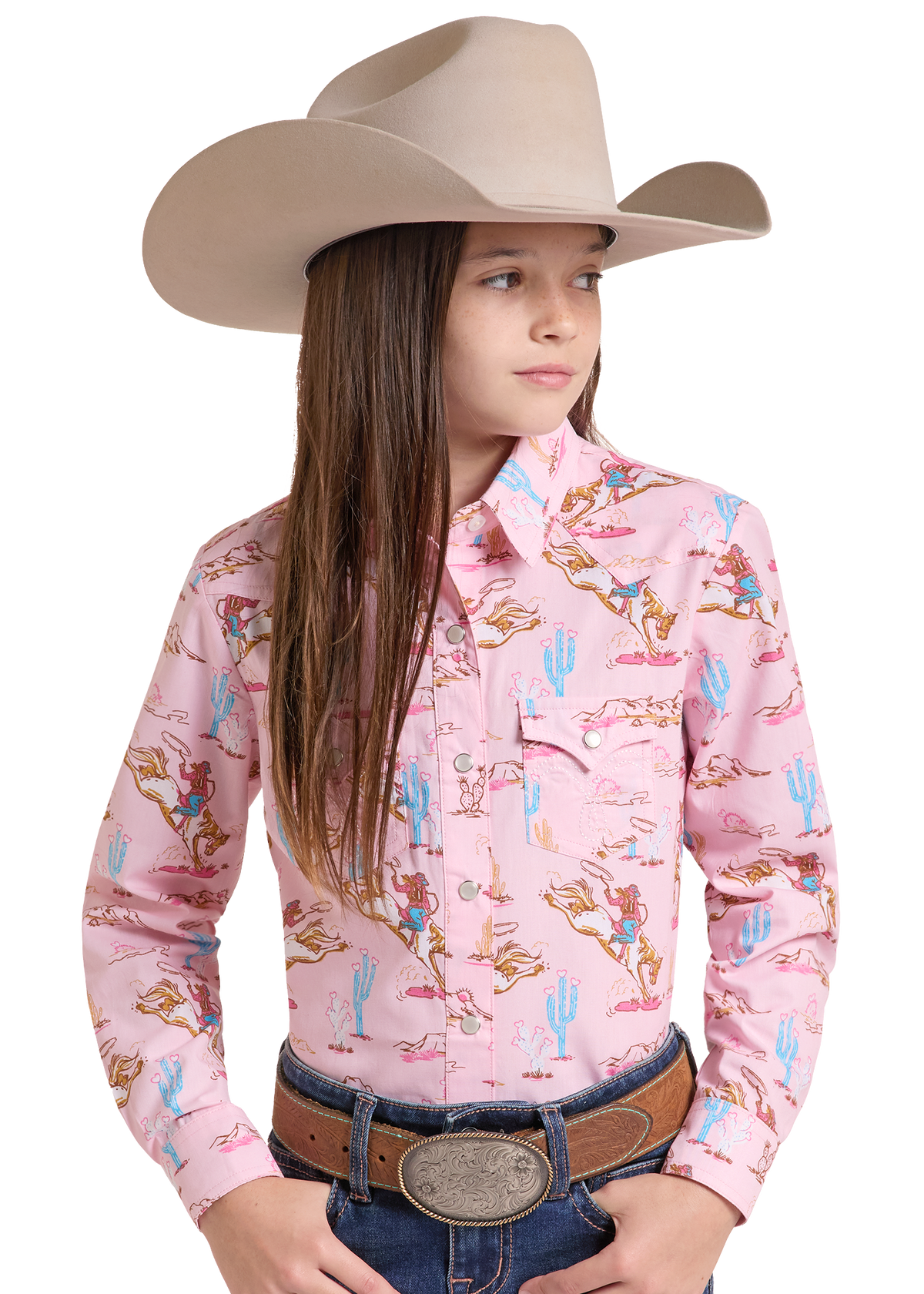 Girl wearing a Light pink long-sleeve western shirt with a cowboy and cactus print with jeans and a cowboy hat. 