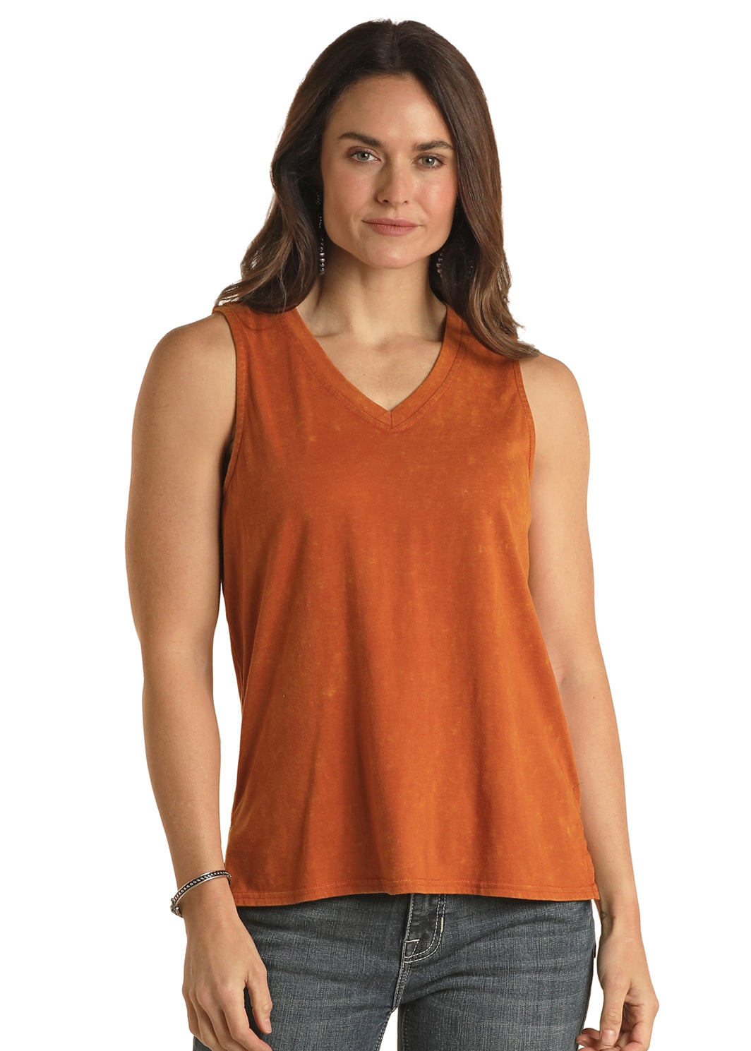 Woman wearing an orange sleeveless top and jeans on a white background