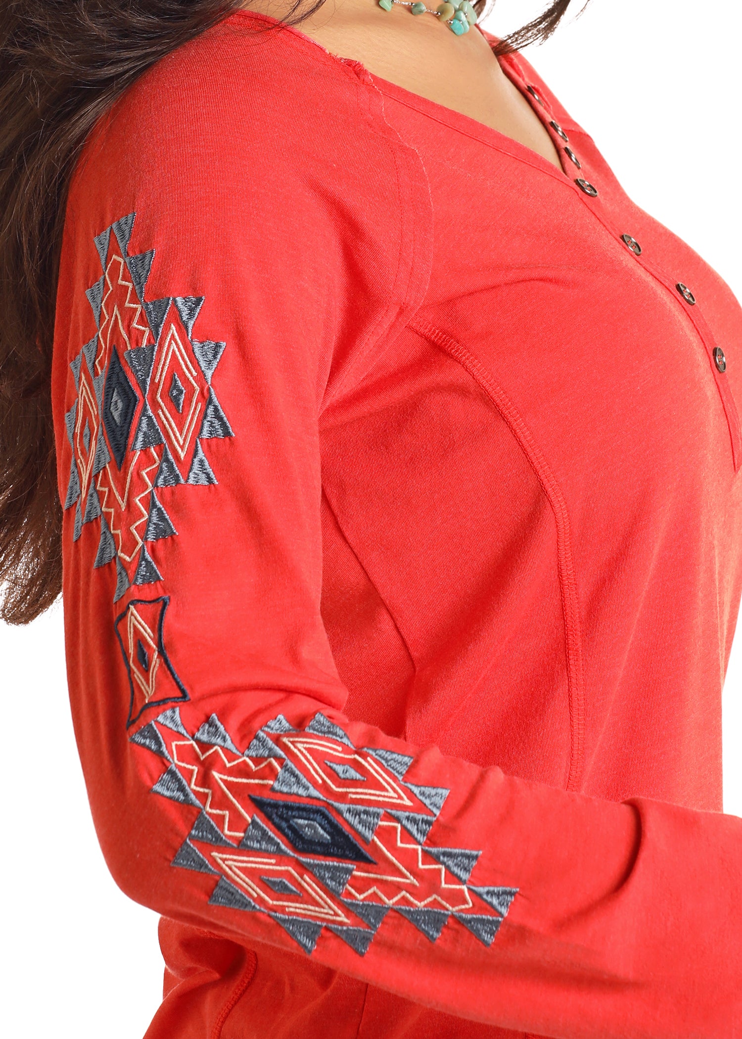 Red long-sleeve top with geometric patterns on the sleeves against a white background