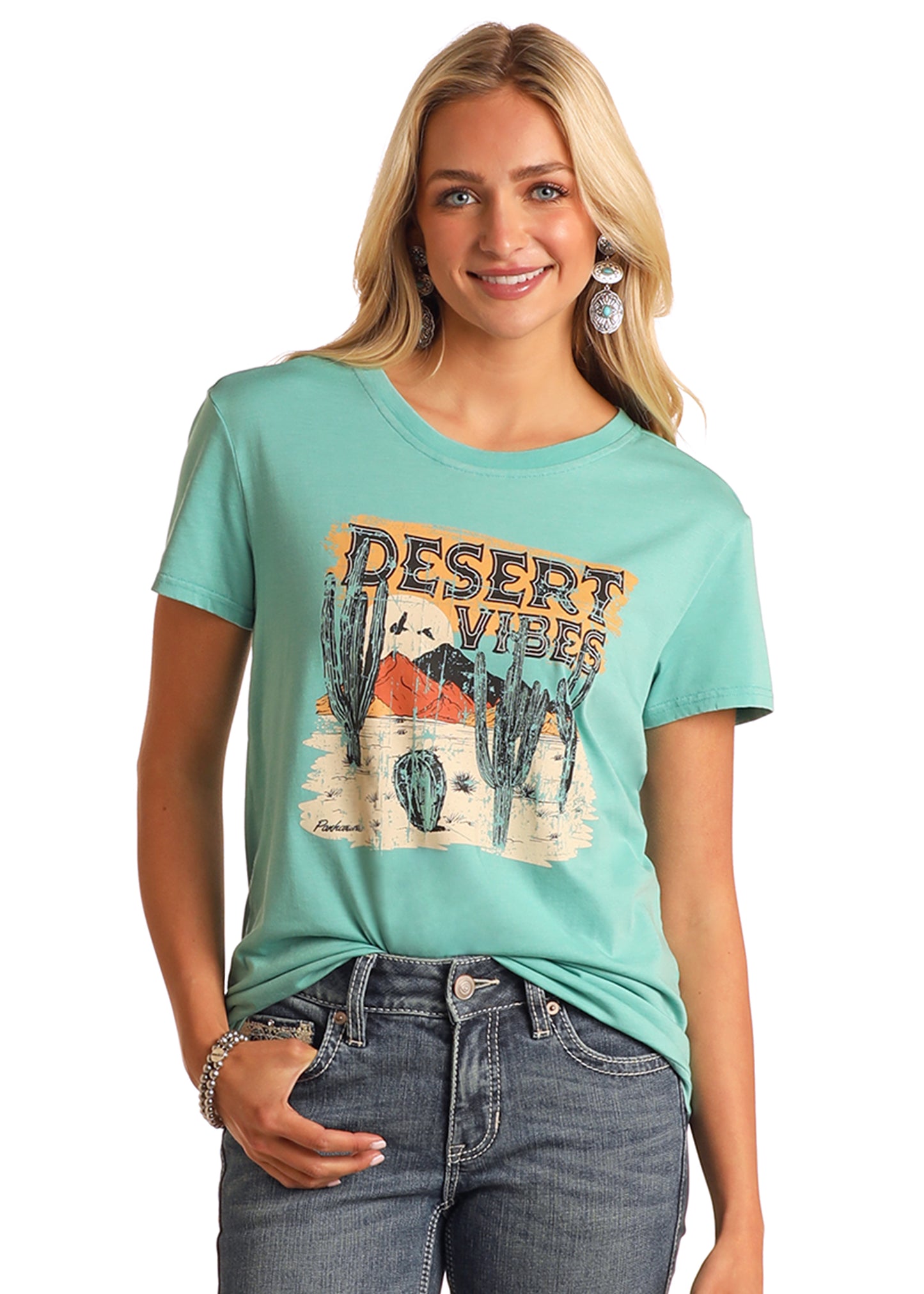Woman wearing a teal t-shirt with 'Desert Vibes' graphic design on a white background