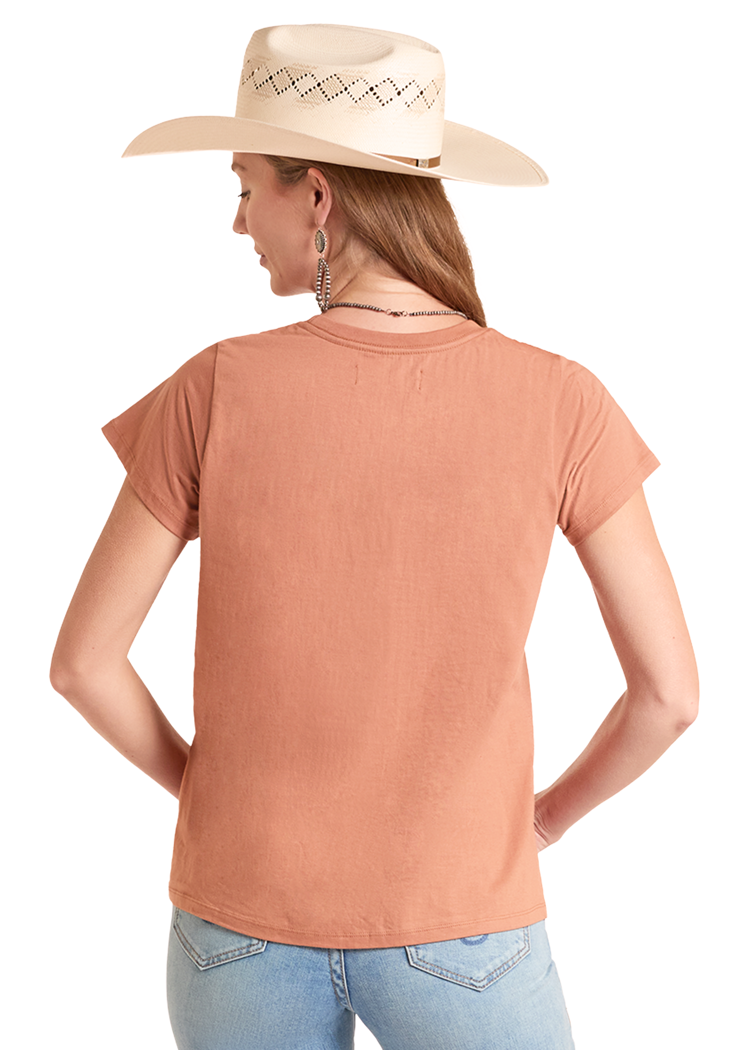 Woman wearing a peach-colored t-shirt and light blue jeans with a beige cowboy hat on a white background