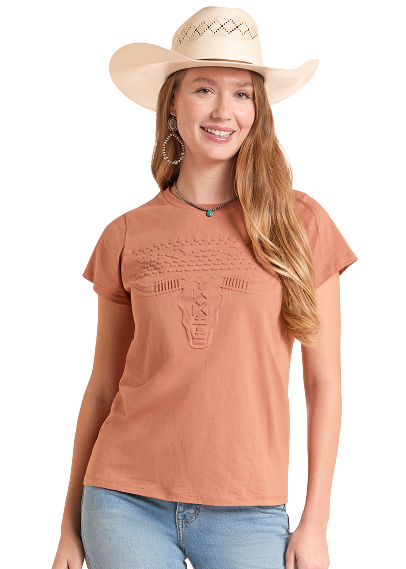 Woman wearing a brown t-shirt with a decorative design, blue jeans, and a beige cowboy hat on a white background.