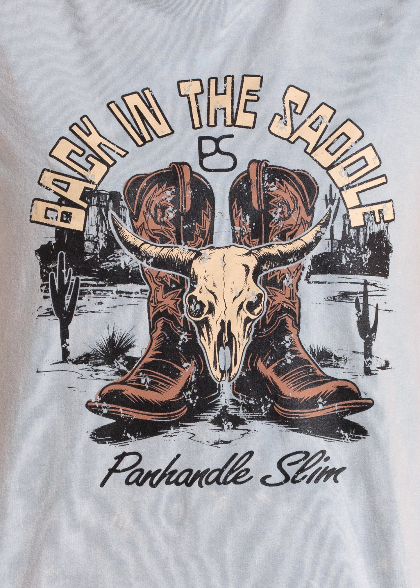 T-shirt with a graphic of cowboy boots and a skull, featuring the text 'Back in the Saddle' and 'Panhandle Slim'.