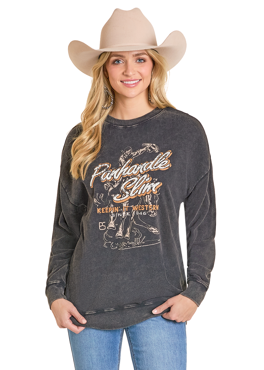 Woman wearing a dark gray sweatshirt with 'Pawhuska' text and blue jeans on a white background
