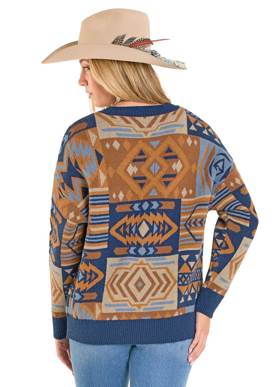 Person wearing a patterned sweater and jeans with a white background