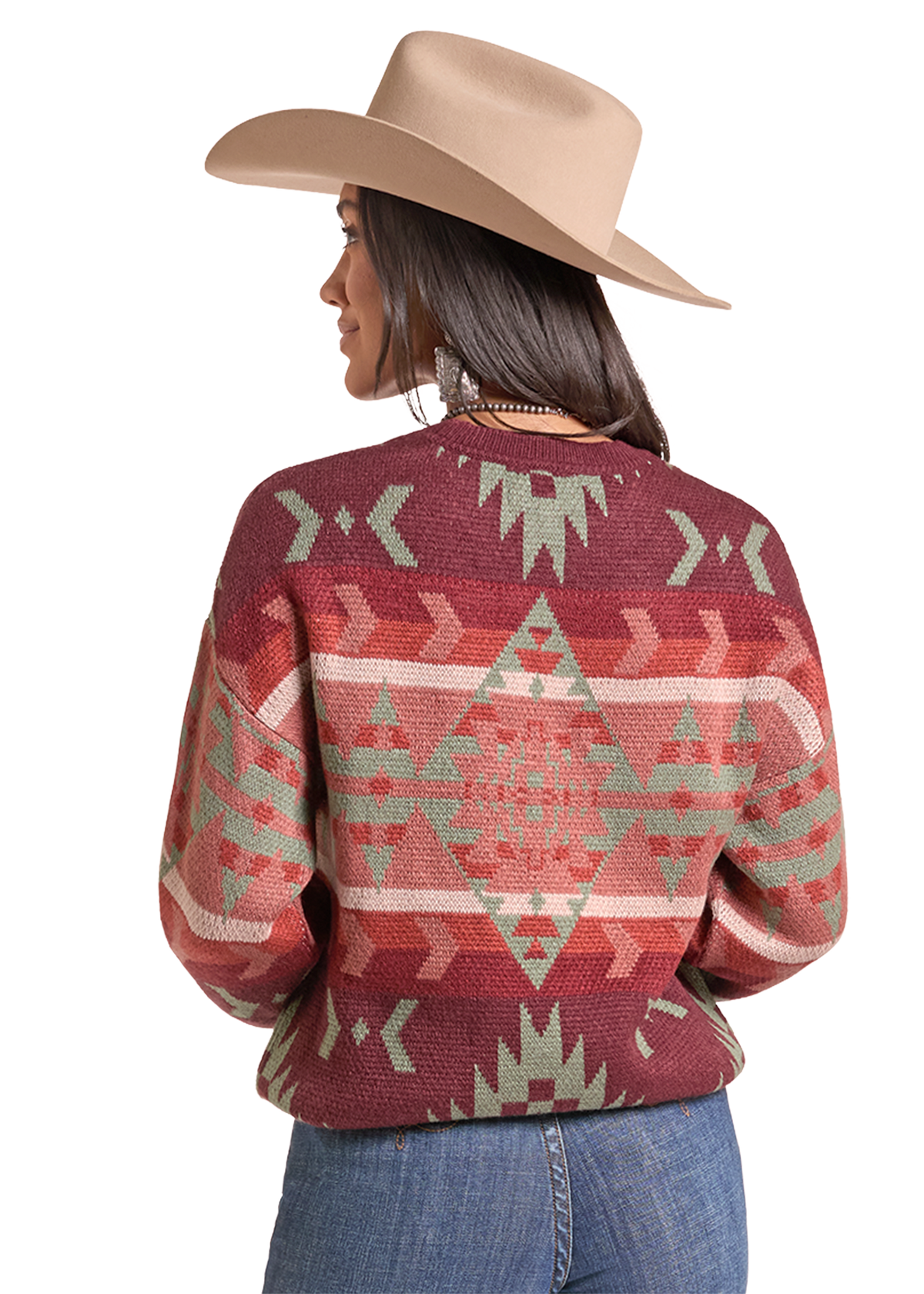 The back of a woman wearing a maroon knit sweater with a Southwestern geometric pattern in sage green and beige, paired with a tan cowboy hat and blue jeans.