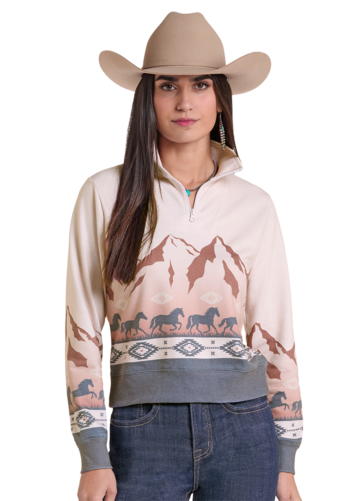 A woman wearing a beige cowboy hat and a quarter-zip pullover sweatshirt with a western mountain and horse print, paired with dark blue jeans.