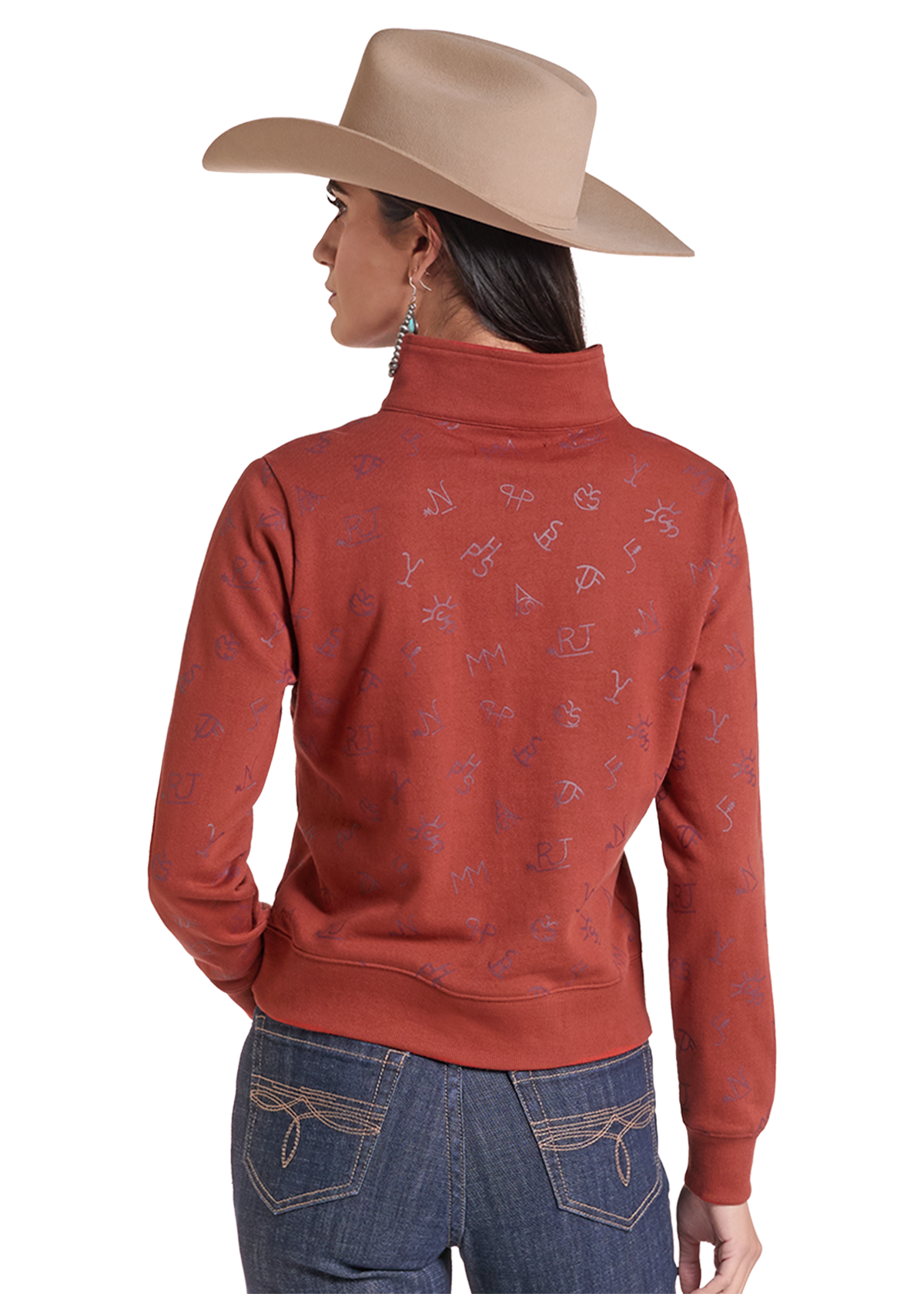 A woman shown from the back wearing a rust-colored long-sleeve mock neck sweatshirt with a subtle allover embroidered monogram pattern, paired with blue jeans and a beige cowboy hat.