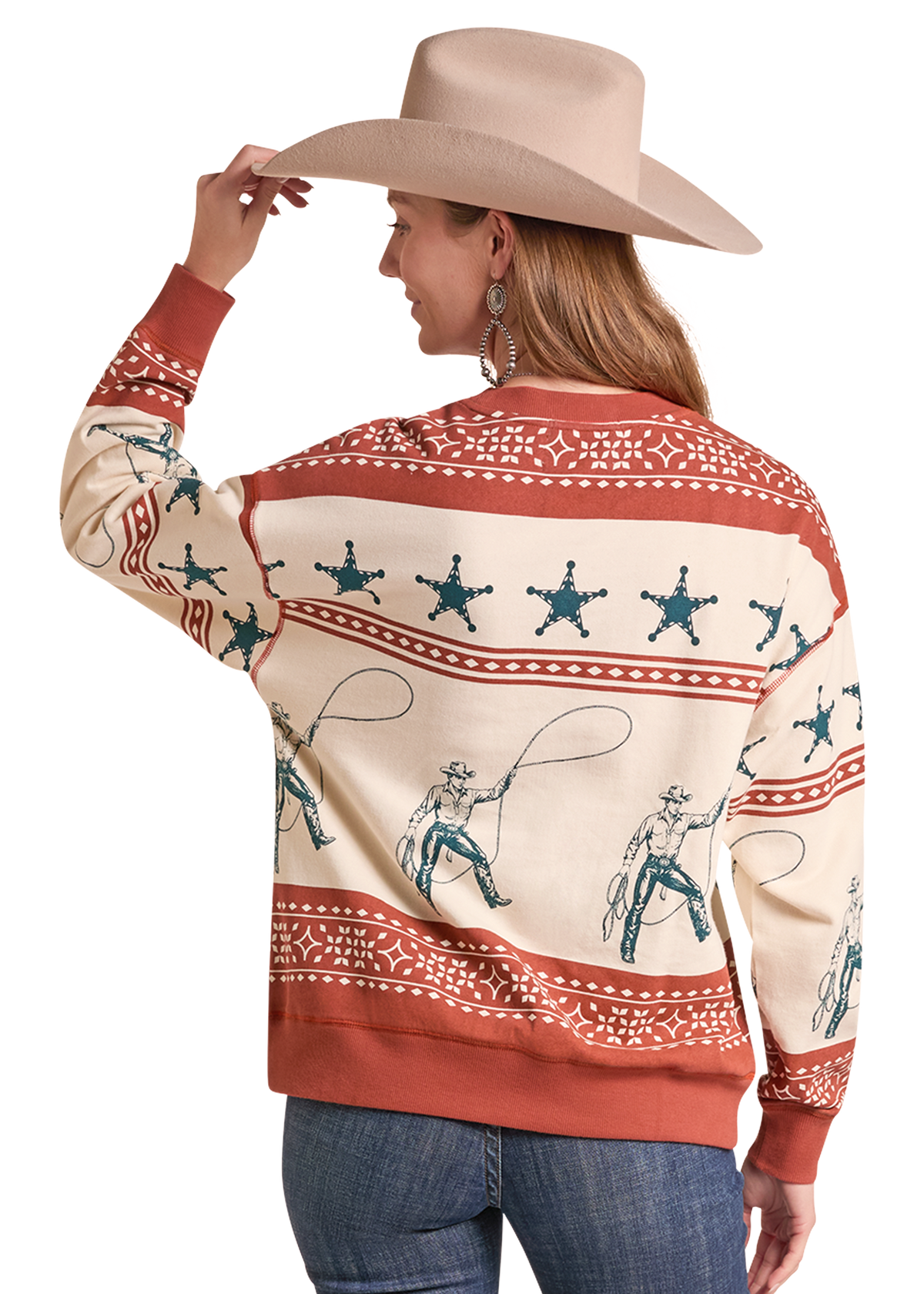 A woman wearing a cream and rust western-themed sweatshirt with blue cowboy print, paired with a beige cowboy hat and blue jeans, shown from the back.