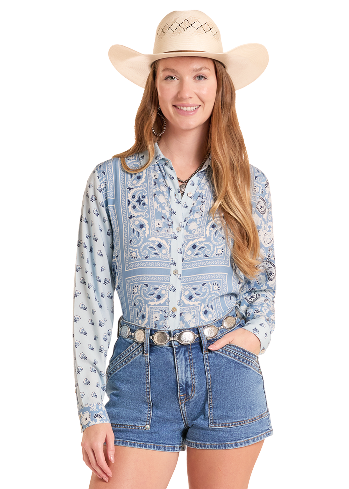 Woman wearing a patterned shirt, denim shorts, and a cowboy hat on a white background