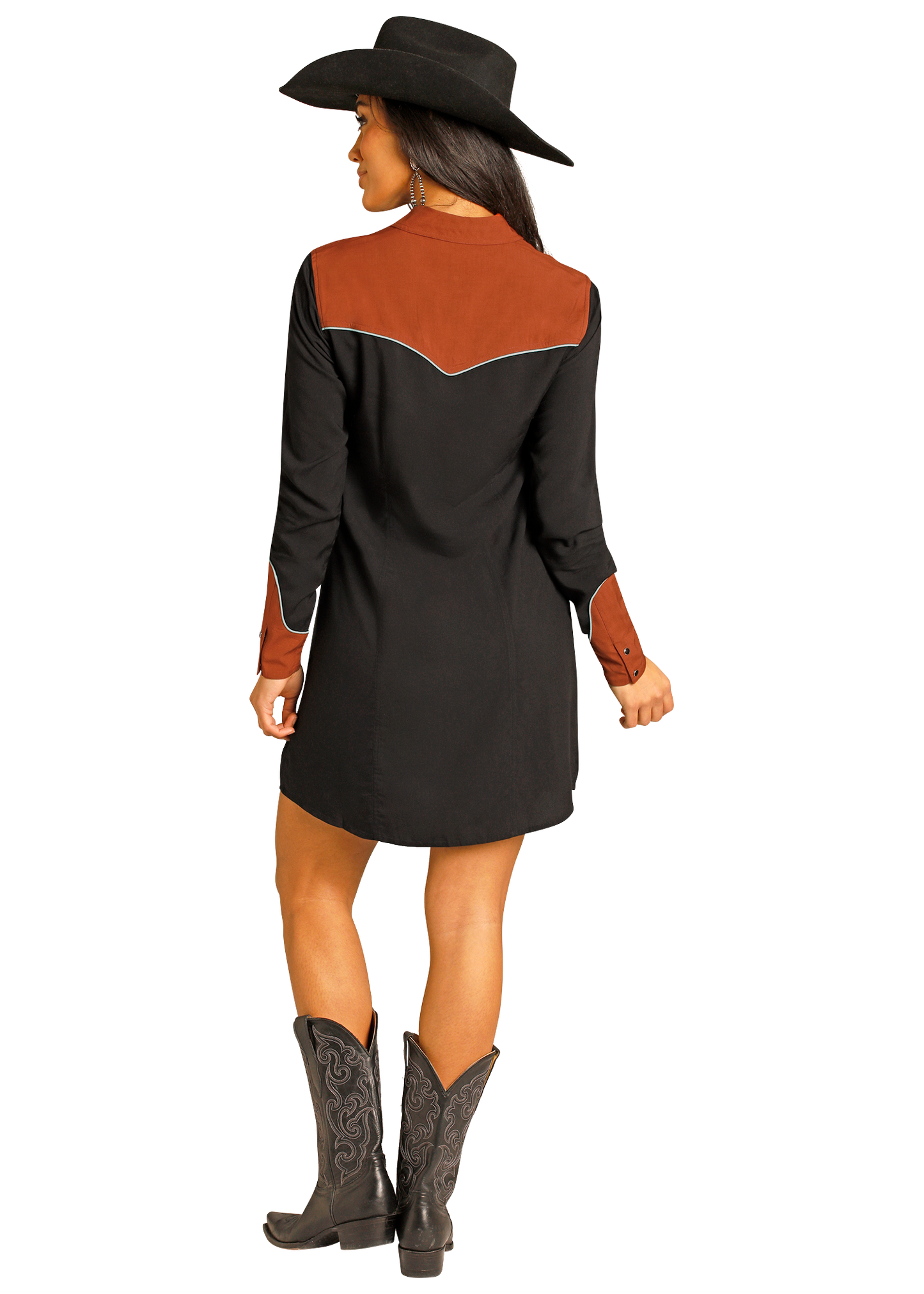 Woman wearing a black dress with brown accents and cowboy boots on a white background