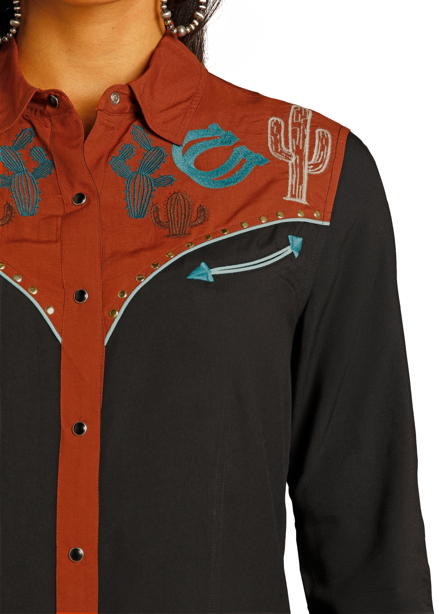 Close-up of a shirt with cowboy-themed embroidery on a white background