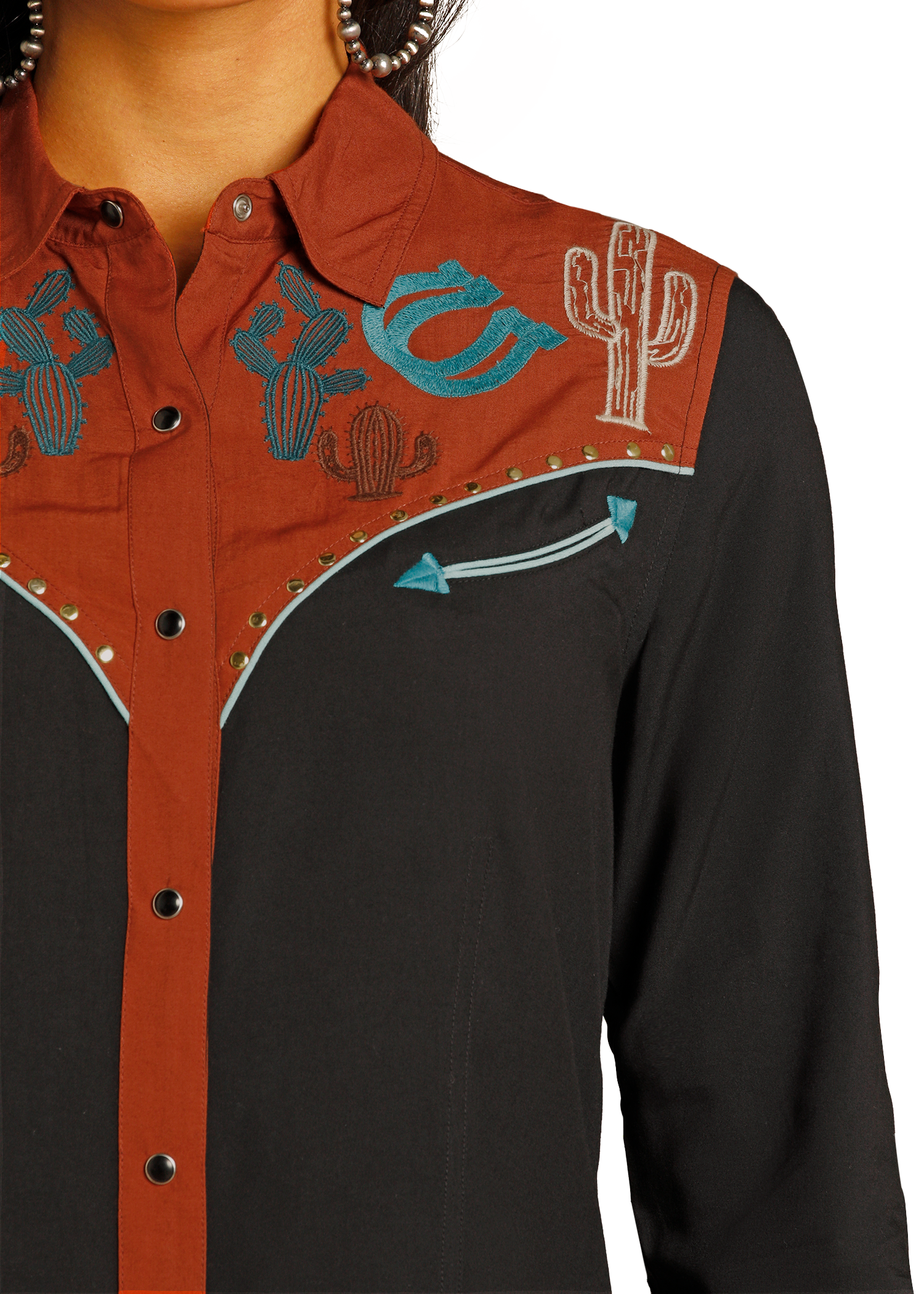 Close-up of a shirt with cowboy-themed embroidery on a white background